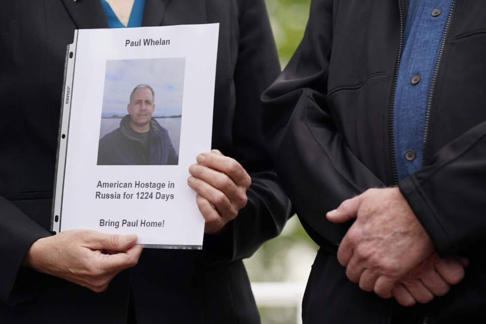 Elizabeth Whelan, left, sister of U.S. Marine Corps veteran and Russian prisoner Paul Whelan, holds a photo of her brother as she stands alongside Joey Reed, father of U.S. Marine Corps veteran and released Russian prisoner Trevor Reed, before a news conference with families of Americans being held hostage or wrongfully detained overseas Wednesday, May 4, 2022, in Washington. (Patrick Semansky/AP)