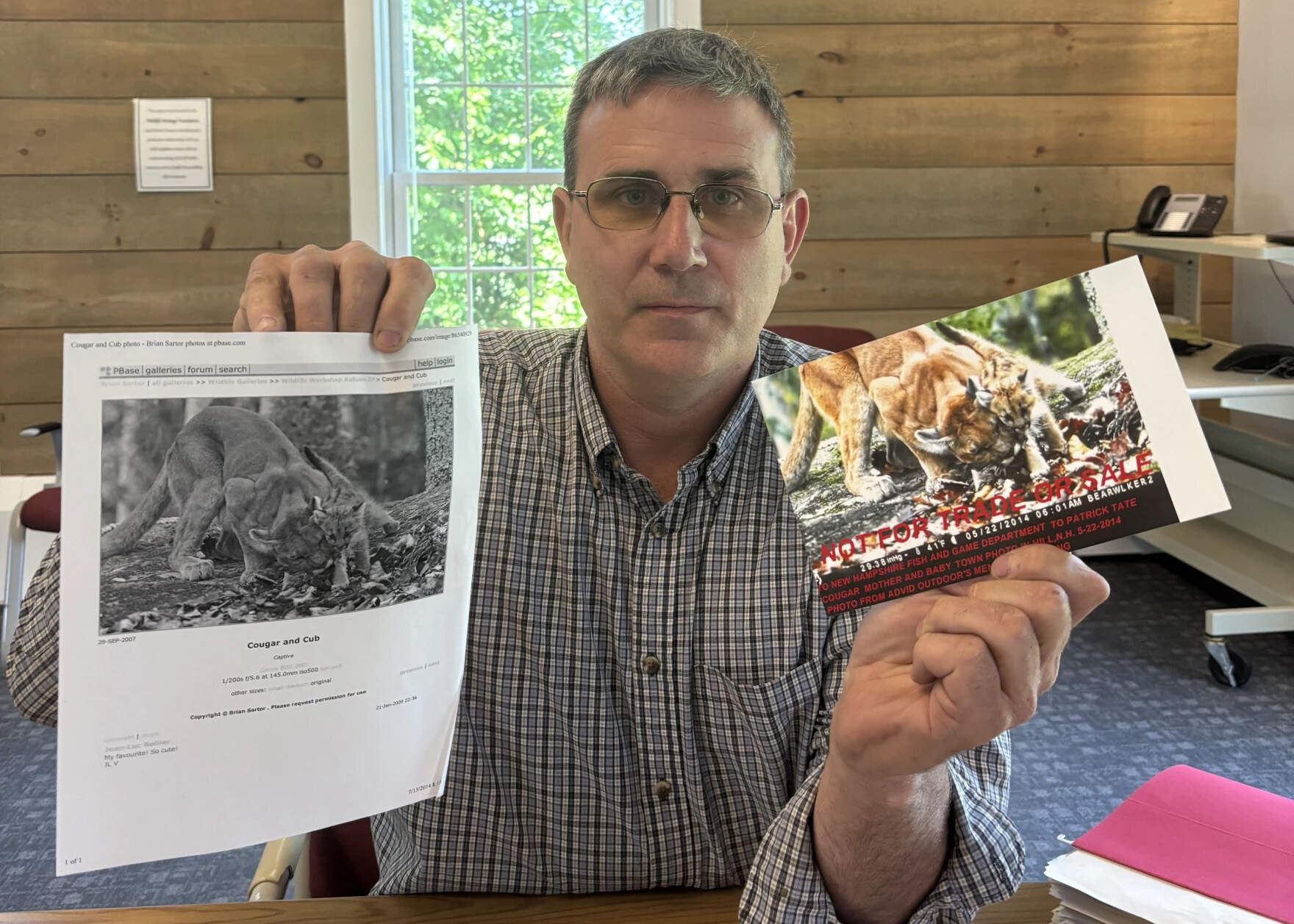 Patrick Tate with New Hampshire Fish and Game shows off a hoax mountain lion sighting submitted to his office. A New Hampshire resident claimed to have a trail camera picture of a mountain lion and her cub, but Tate soon found the same image online. (Kate Dario/NHPR)