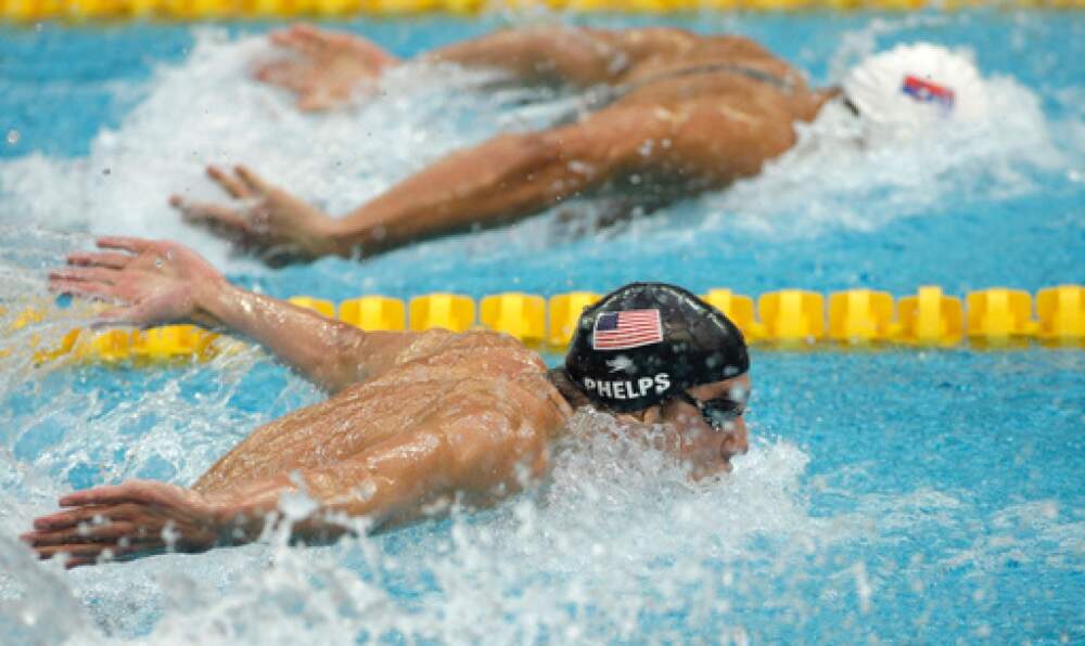 United States' Michael Phelps, front, swims beside Serbia's Milorad Cavic in the men's 100-meter butterfly final during the swimming competitions in the National Aquatics Center at the Beijing 2008 Olympics in Beijing, Saturday, Aug. 16, 2008. Phelps, with nothing to lose, took an extra half-stroke that sent him slamming into the wall a hundredth of a second ahead of Cavic. (AP Photo/Petr David Josek, File)