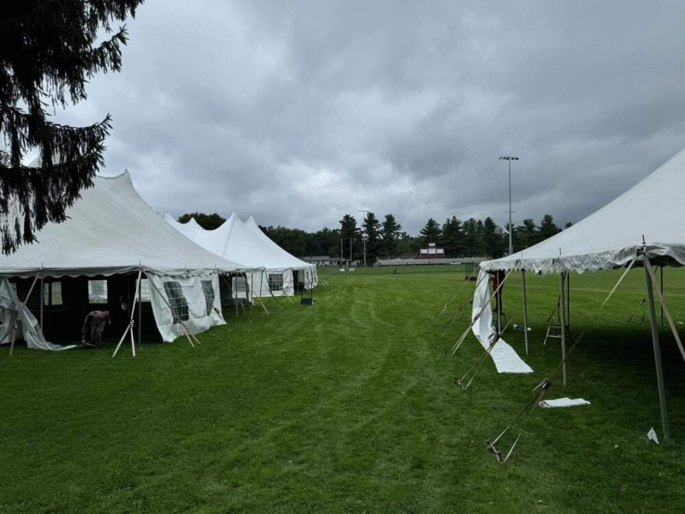 White wedding tents are being erected at North Country Union High in Newport on Aug. 22, 2024, to accommodate students after PCBs were detected at high levels throughout the school. (Courtesy of Chris Young via Vermont Public)
