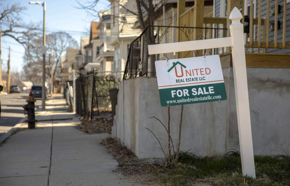 A 'For Sale' sign by a house on Ballou Avenue in Mattapan. (Robin Lubbock/WBUR)