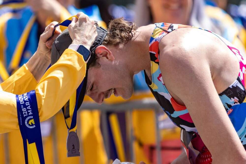 Denver resident David French receives his metal after finishing the Boston Marathon. (Jesse Costa/WBUR)