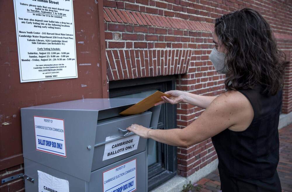 A voter places her ballot into an official drop box in Cambridge. (Robin Lubbock/WBUR)