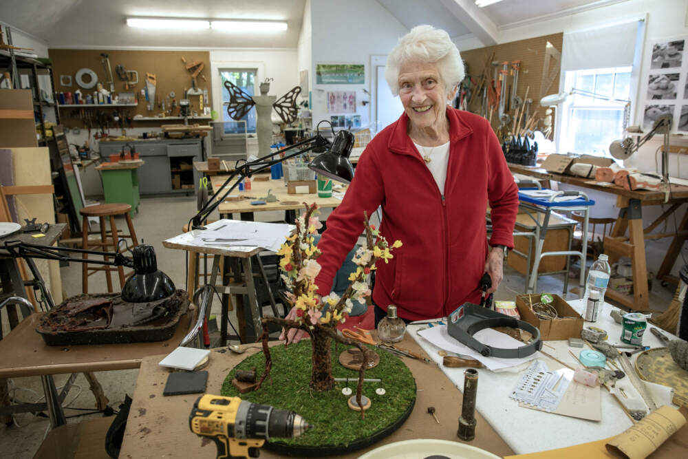 Nancy Schön with a recent sculpture that shows the branches of government, once blossoming, now broken. (Robin Lubbock/WBUR)