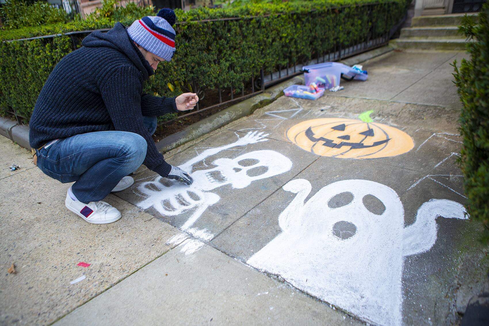 For Halloween, a resident draws chalk ghosts and a Jack-o'-lantern on the sidewalk outside his apartment building on Commonwealth Avenue. (Jesse Costa/WBUR)