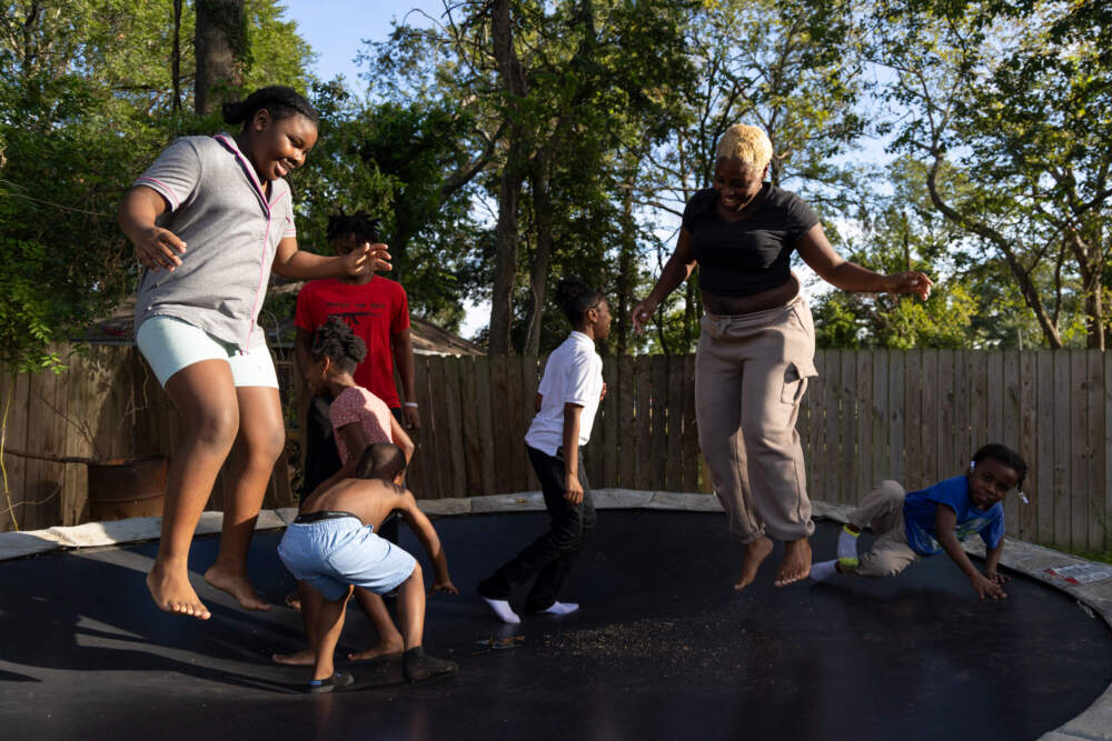 Terranisha Collins jumps on a trampoline with her children. (Lucio Vasquez/Here & Now)