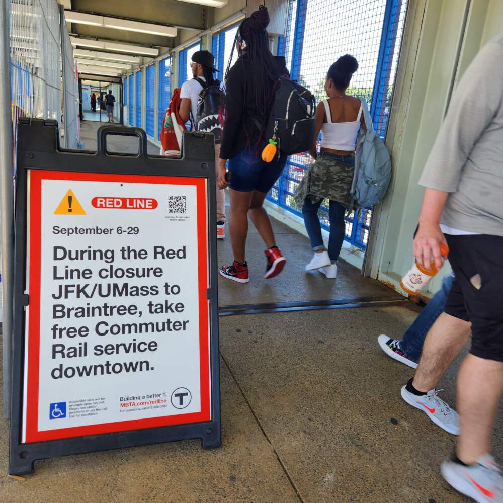 A sign at JFK/UMass station asks commuters to try the commuter rail during while the MBTA repairs the Braintree branch of the Red Line. (Andrea Perdomo Hernandez/WBUR)