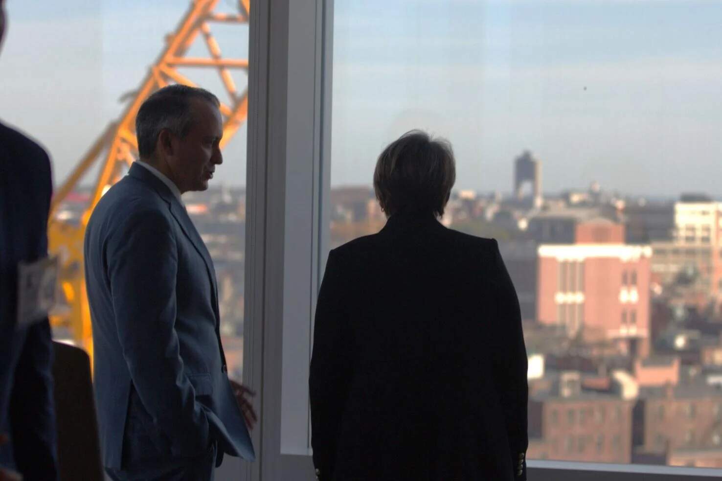 Rep. Aaron Michlewitz and Gov. Maura Healey look out the window of the One Congress building in downtown Boston, which holds State Street's headquarters, on Wednesday, Oct. 25, 2023. (SHNS)