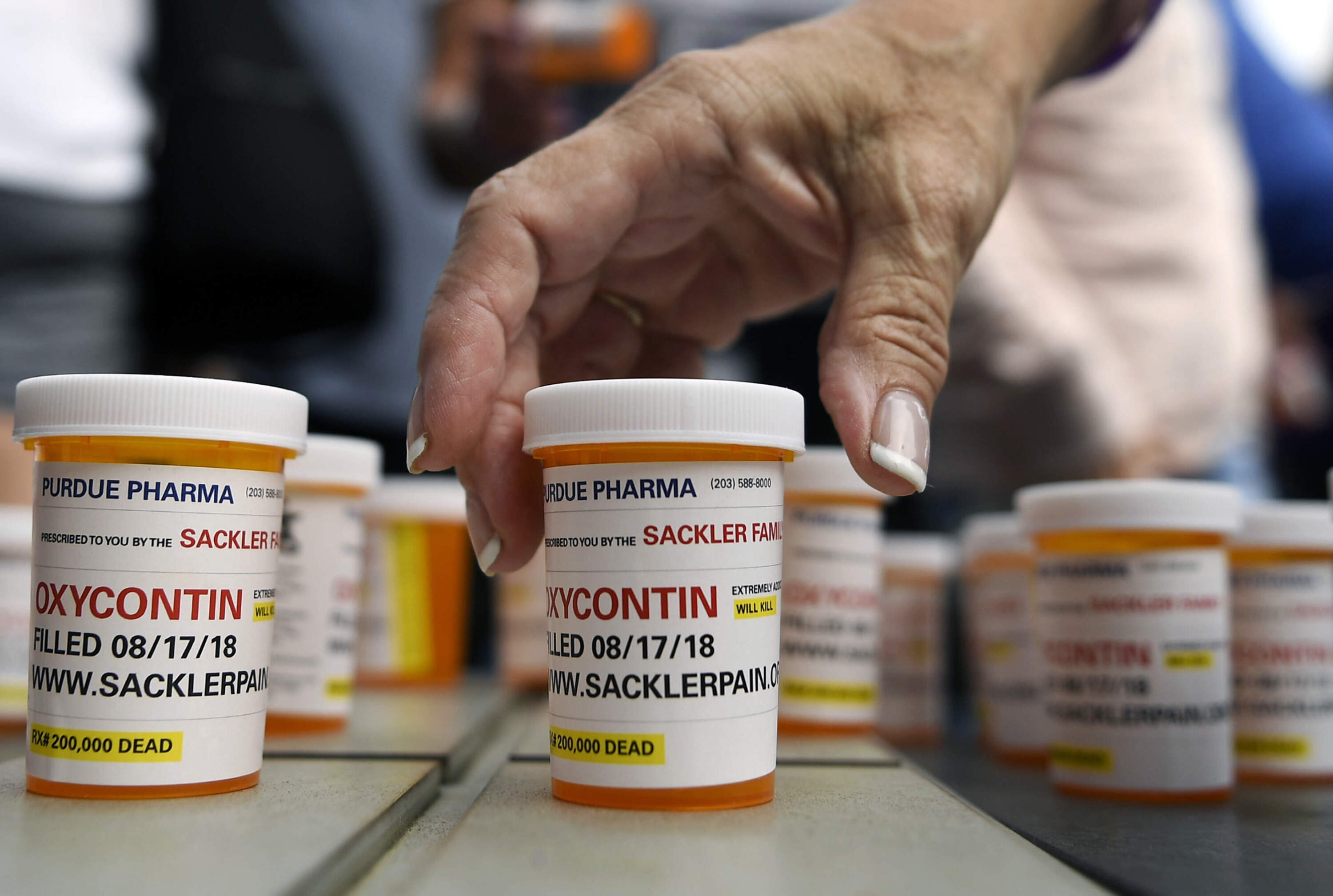 In 2019, nearly 30 West Virginia hospitals and 10 affiliates in Kentucky banded together to sue some of the country’s largest opioid companies, saying they flooded Appalachia with powerful painkillers and forced medical centers to deal with the financial repercussions. In this photo family and friends who have lost loved ones to OxyContin and opioid overdoses leave protest messages written on pill bottles outside the headquarters of Purdue Pharma. (Jessica Hill/AP)