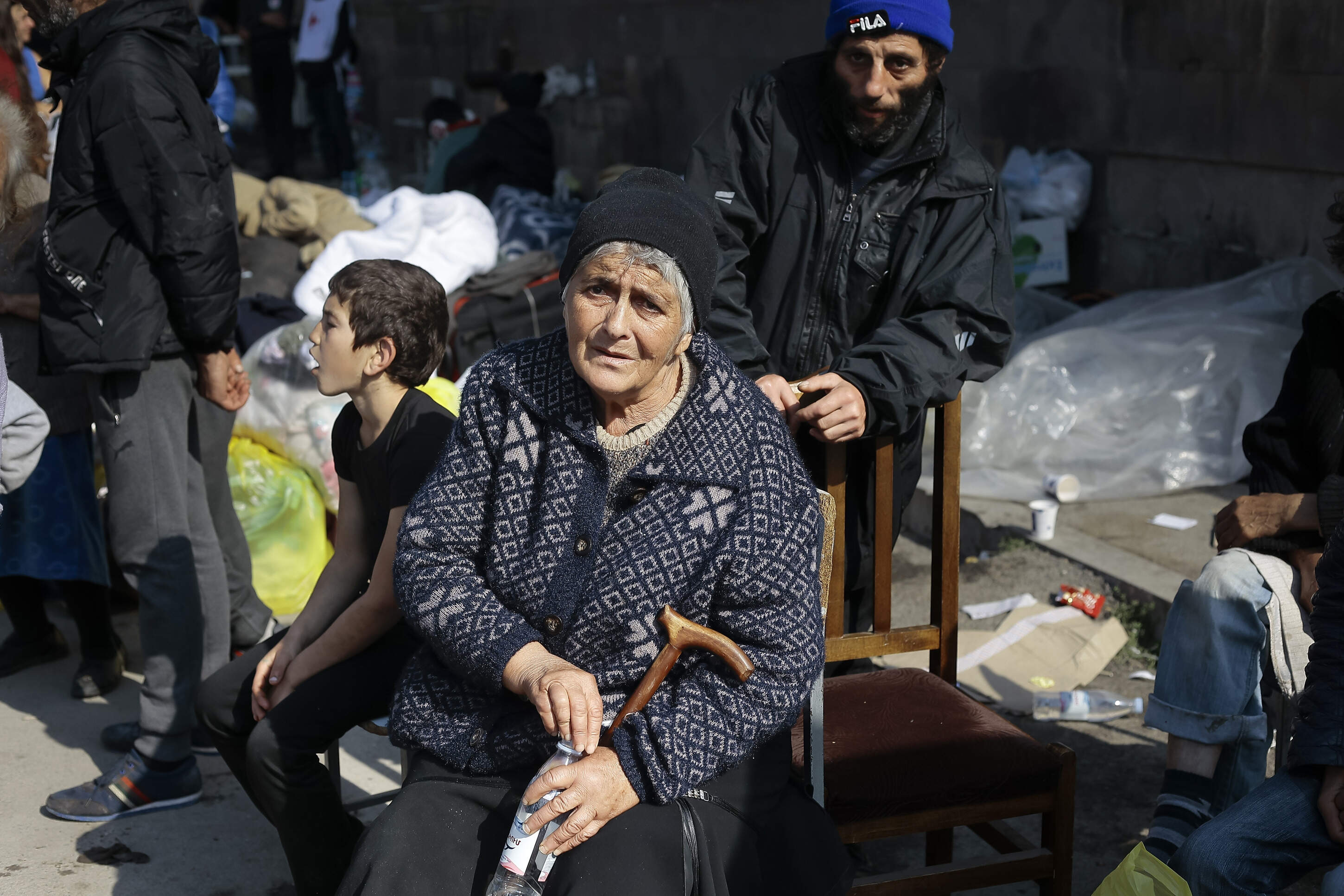 Ethnic Armenians from Nagorno-Karabakh sit next to their belongings near a tent camp after arriving to Armenia's Goris in Syunik region, Armenia, on Saturday, Sept. 30, 2023. A human rights organization representing ethnic Armenians has submitted evidence to the International Criminal Court arguing that Azerbaijan is committing an ongoing genocide against them. (Vasily Krestyaninov/AP)