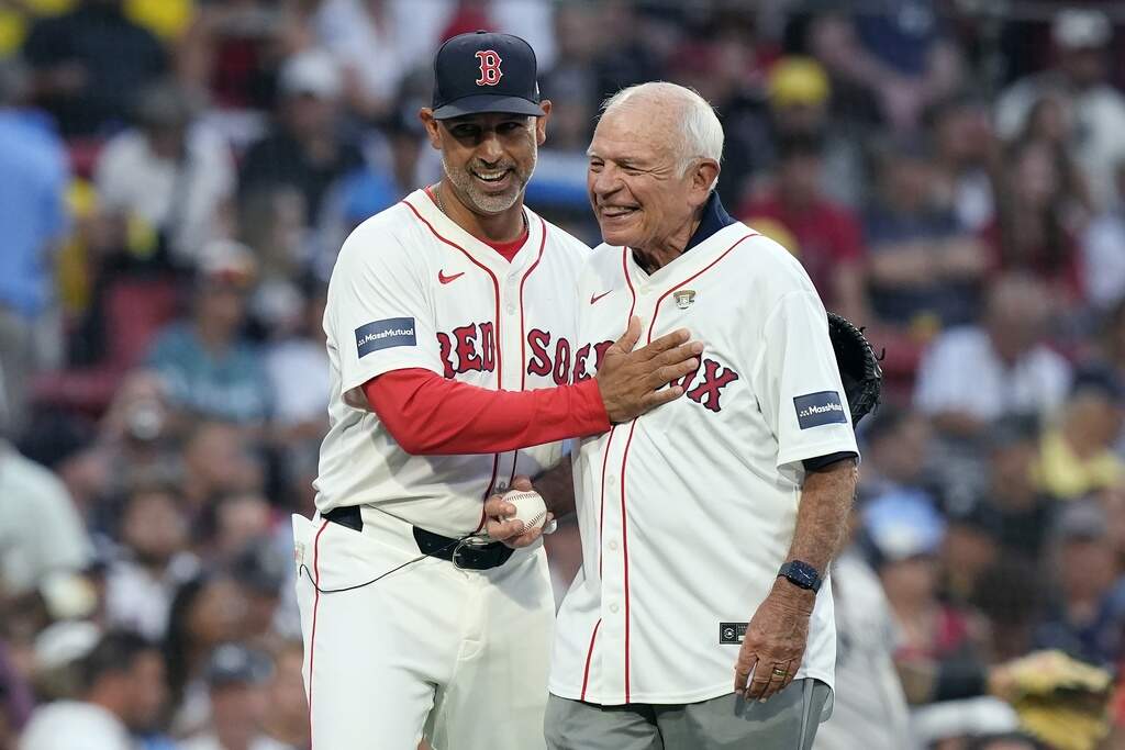 Former Boston Red Sox radio announcer Joe Castiglione with manager Alex Cora after throwing the ceremonial first pitch before a baseball game against the New York Yankees, Sunday, July 28, 2024, in Boston. (AP Photo/Michael Dwyer)