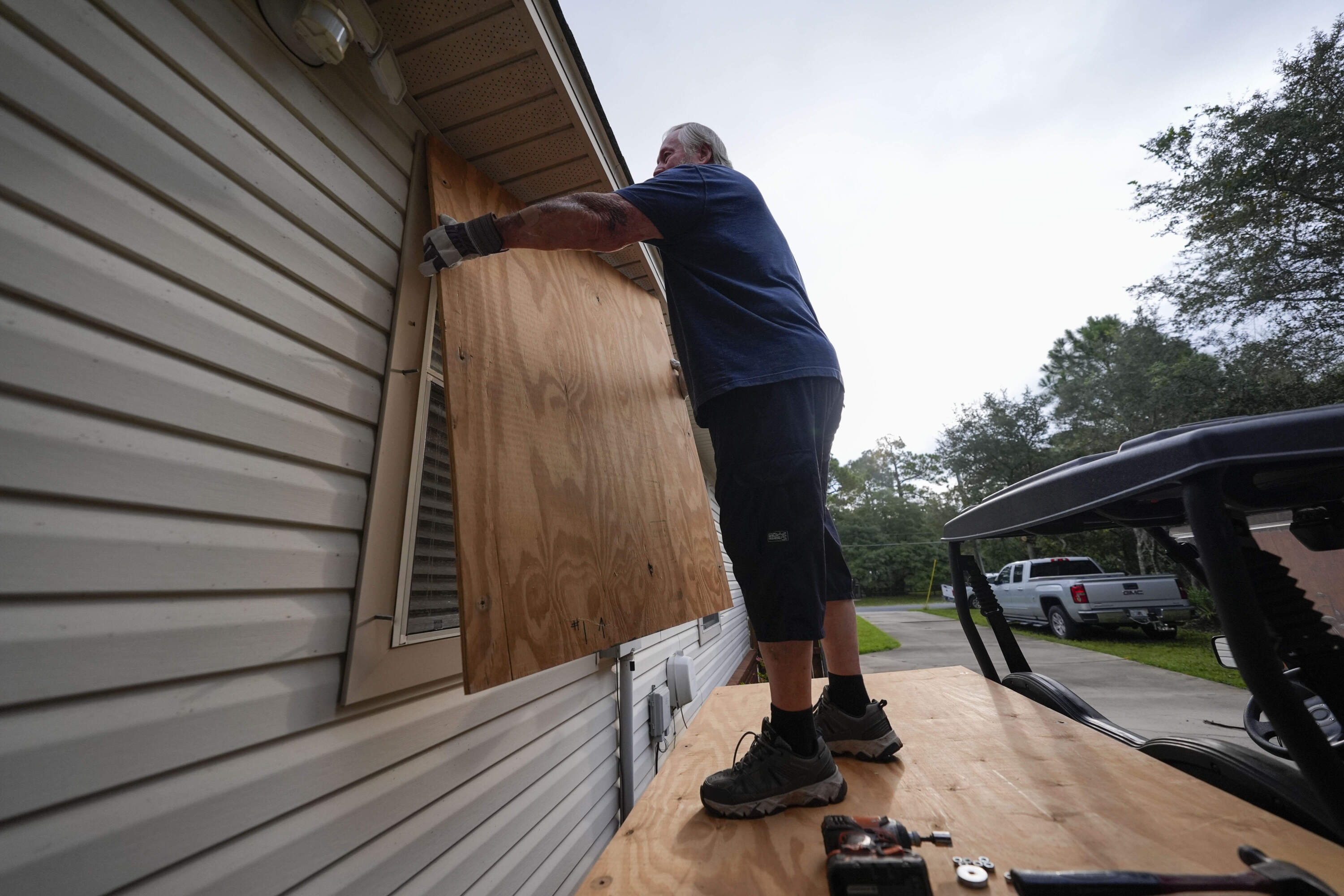 Dave McCurley boards up the windows to his home in advance of Hurricane Helene, expected to make landfall Wednesday. (Gerald Herbert/AP)