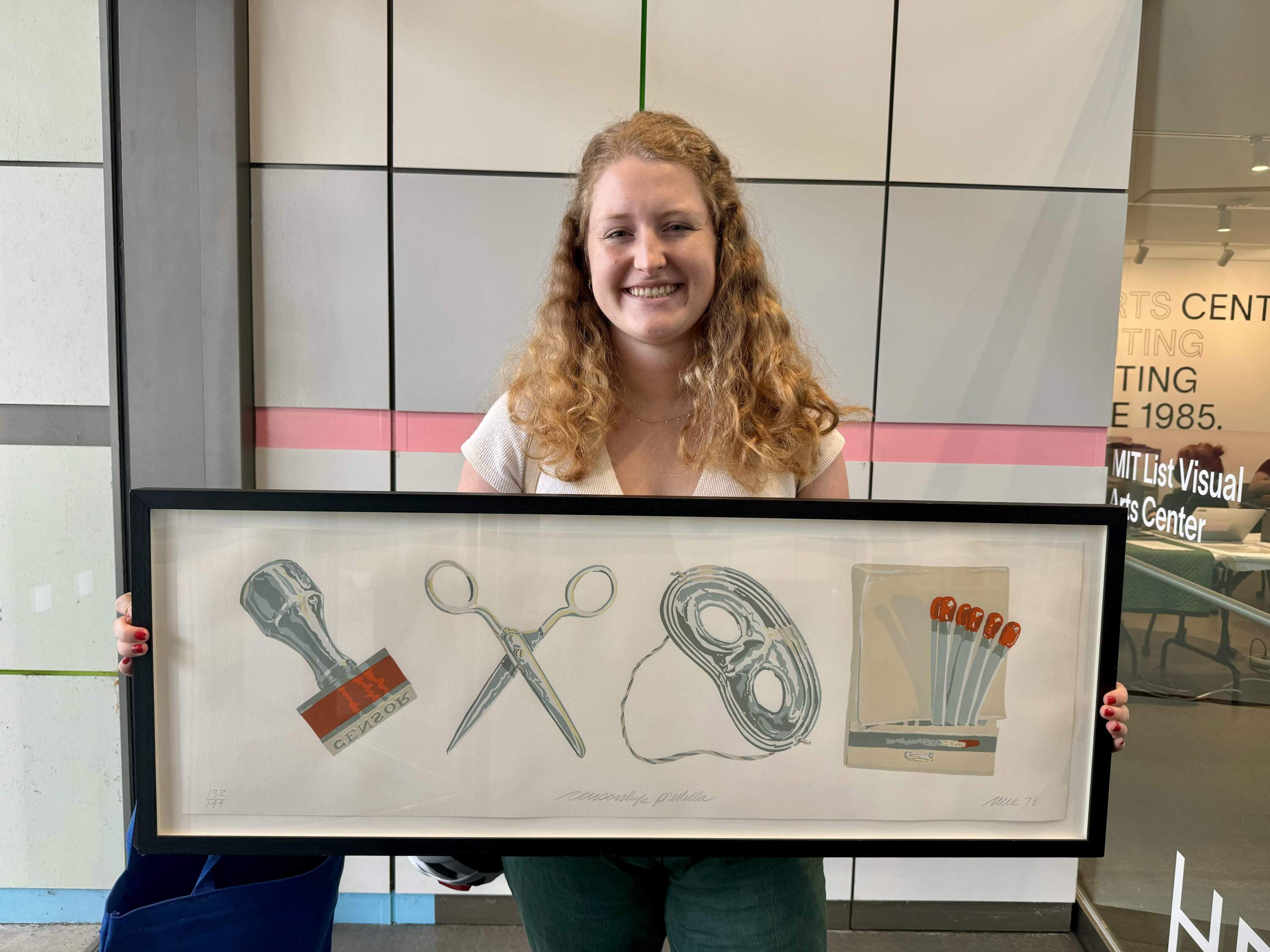 Bridget Schippers, a political science graduate student, with “Censorship Predella” by Don Nice, the work she decided to take home for the school year. (Maddie Browning/WBUR)