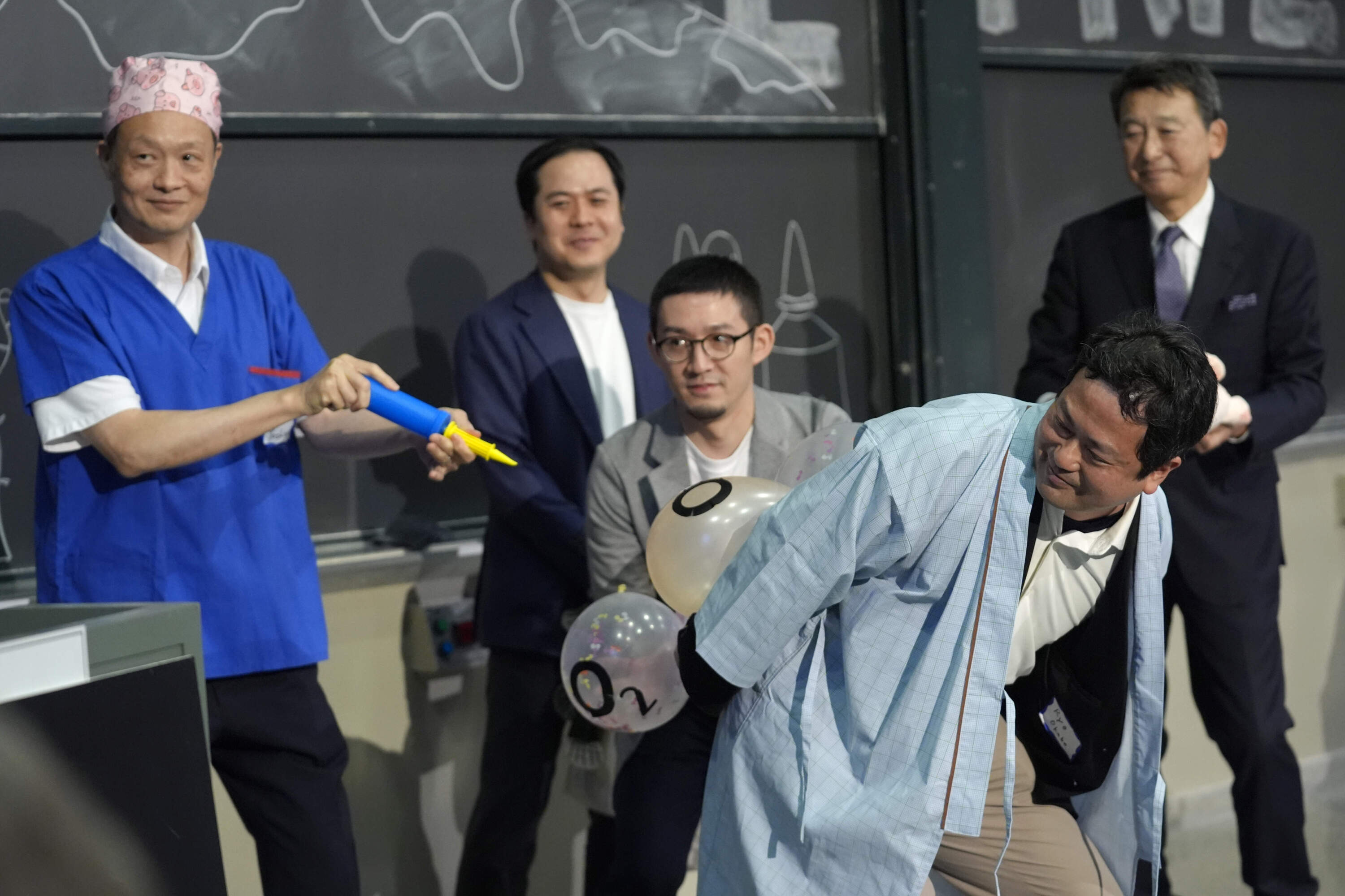 A team of researchers perform a demonstration during a performance showing that many mammals are capable of breathing through their anus while accepting the 2024 Ig Nobel prize in physiology. (Steven Senne/AP)