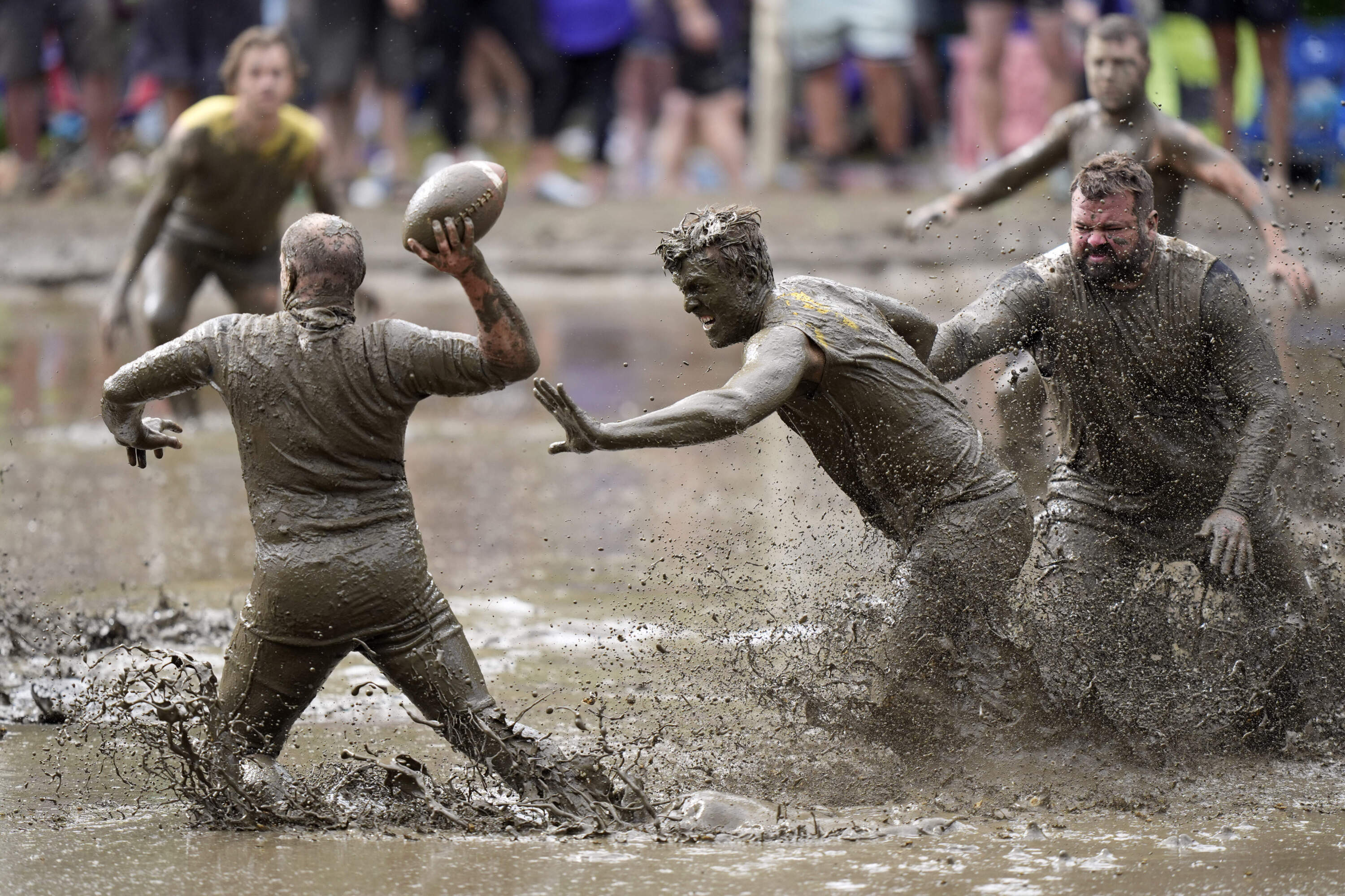 The Mudshark's Jevin Smith, center, gets around Muddas' blocker Kurt Mailloux to put pressure on quarterback Jay Holder in a football game at the 2024 Mud Bowl Sunday, Sept. 8, 2024, in North Conway, N.H. (Robert F. Bukaty/AP)