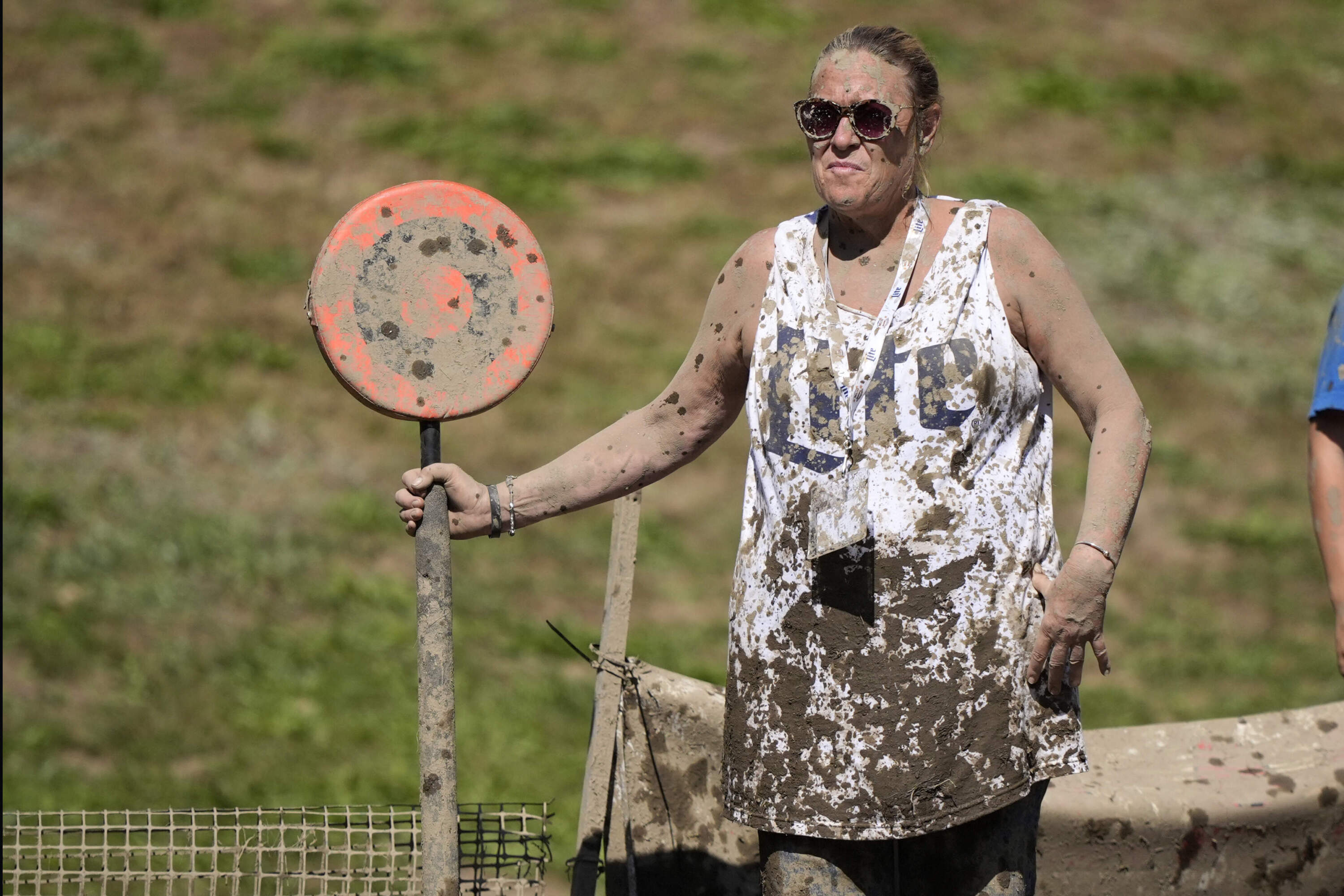Mud-splattered sideline official Kellie Gramstorff holds a first down marker during a football game at the Mud Bowl. (Robert F. Bukaty/AP)
