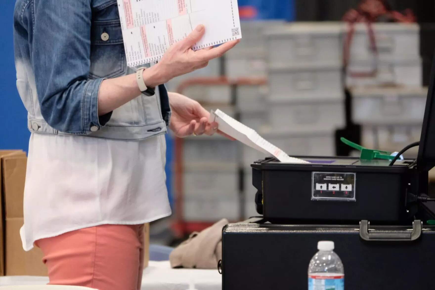 A poll worker feeds in absentee ballots inside of Londonderry's polling place. (Todd Bookman/NHPR)