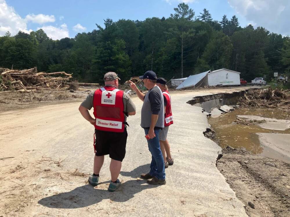 Lyndon Municipal Administrator Justin Smith, center, surveys flood damage in August with volunteers from the American Red Cross. (Peter Hirschfeld/Vermont Public)