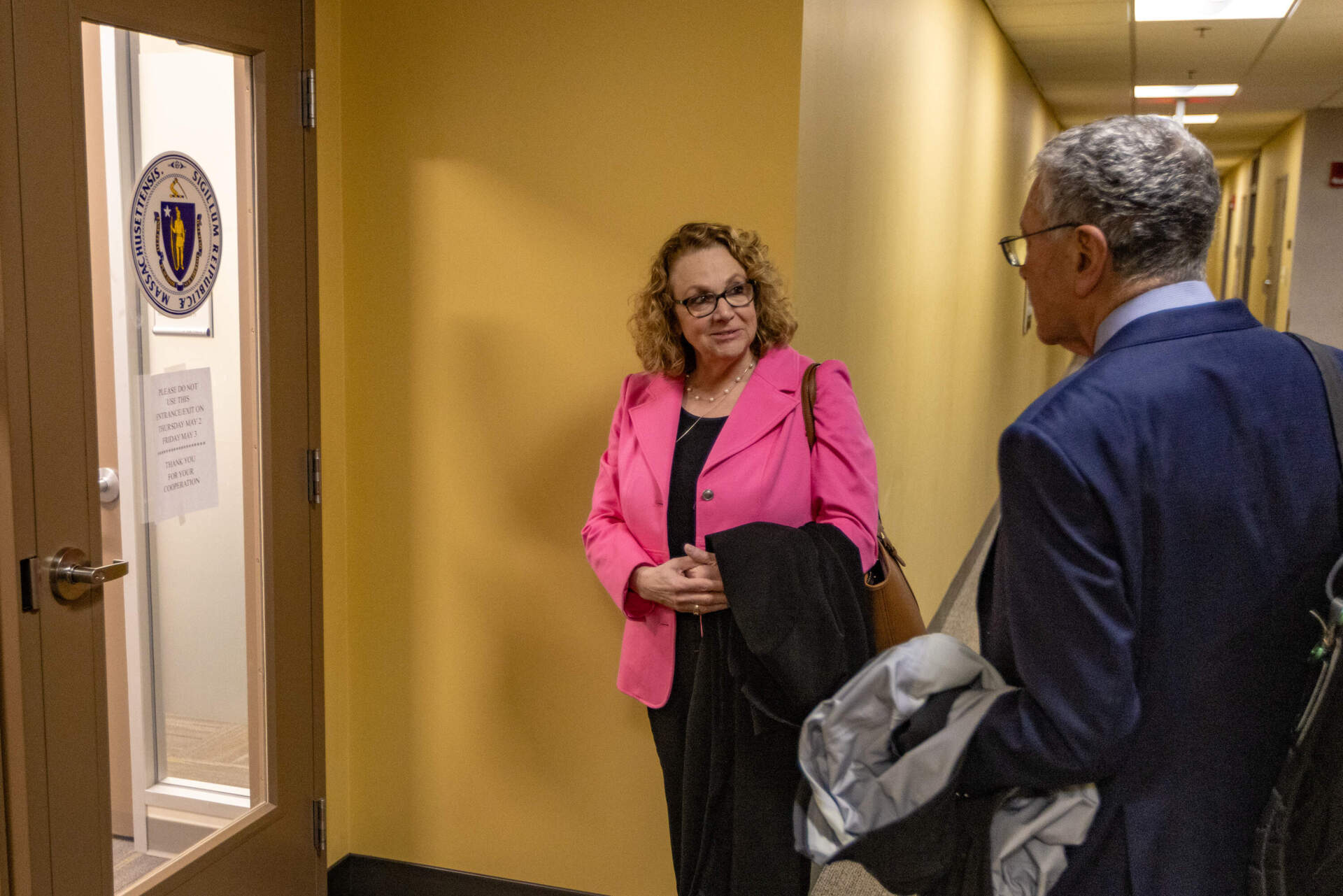 Then-suspended Cannabis Control Commission Chair Shannon O'Brien waits outside of the hearing room to meet with Treasurer Deborah Goldberg. (Jesse Costa/WBUR)