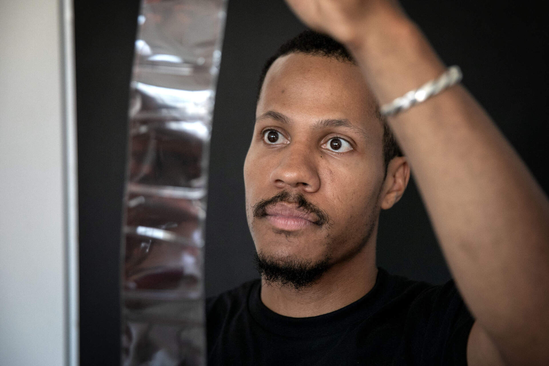 Filmmaker Mushen Kieta looks through images captured on 120 film at his studio in Boston. (Robin Lubbock/WBUR)