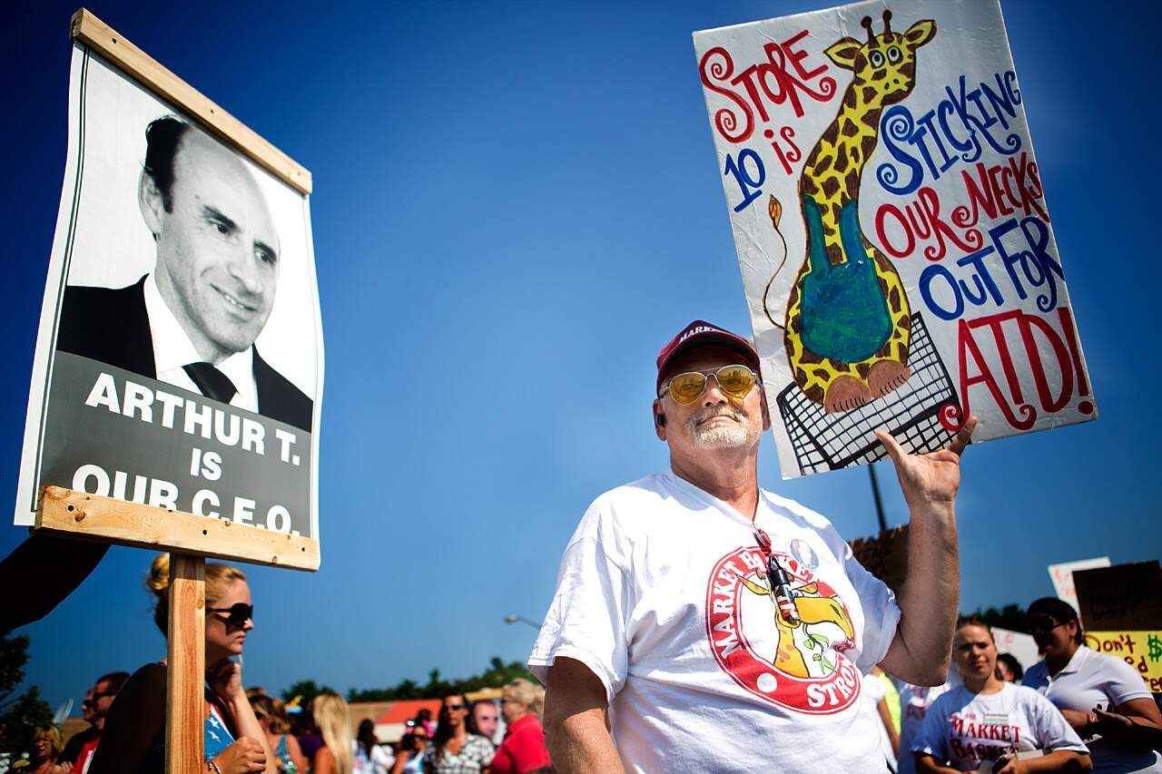 An employee from store 10 in Methuen holding a protest sign during the rally. (Jesse Costa/WBUR)