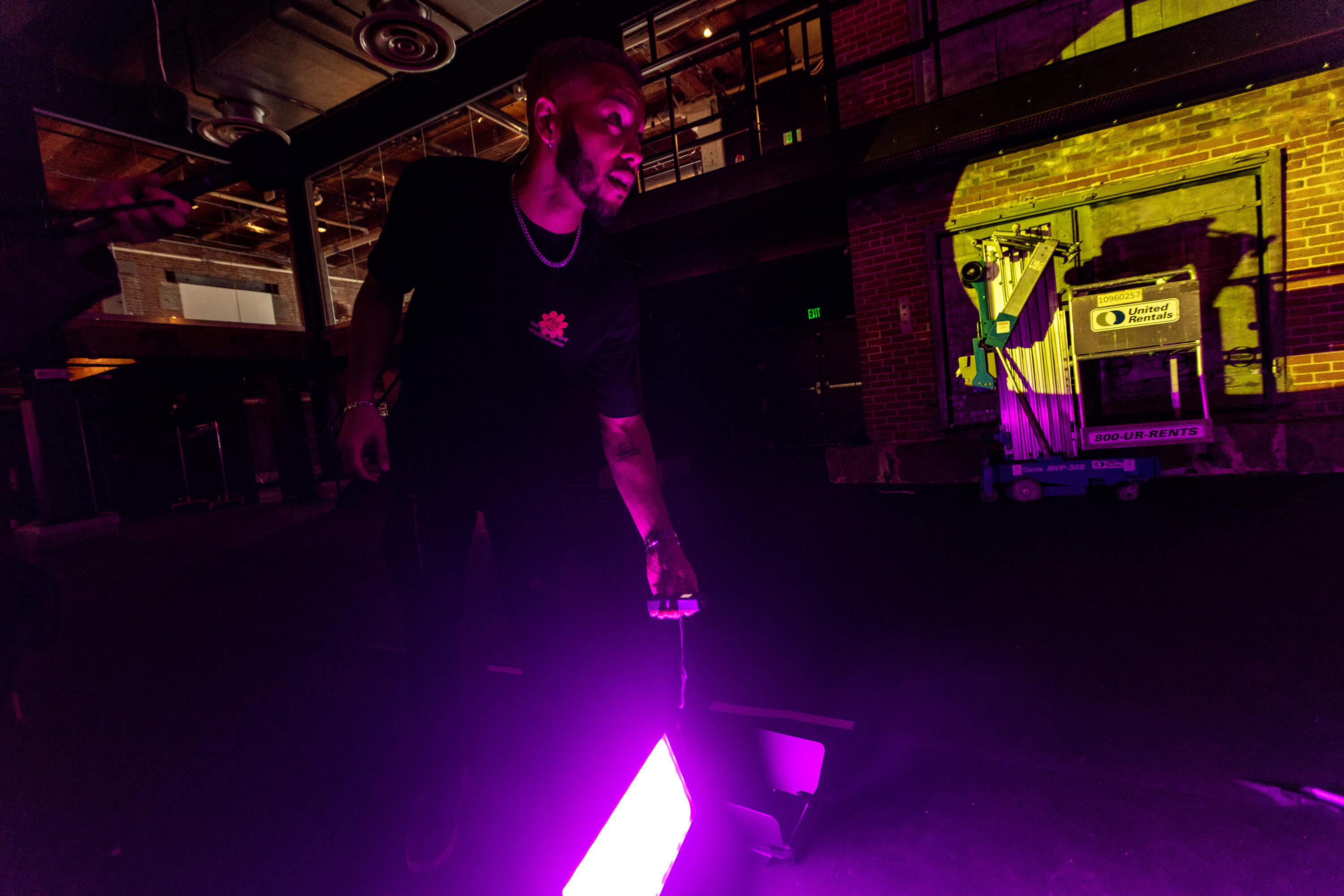 Caleb Hawkins makes adjustments to a light projector during a test at MASARY Studios for an upcoming project. (Jesse Costa/WBUR)
