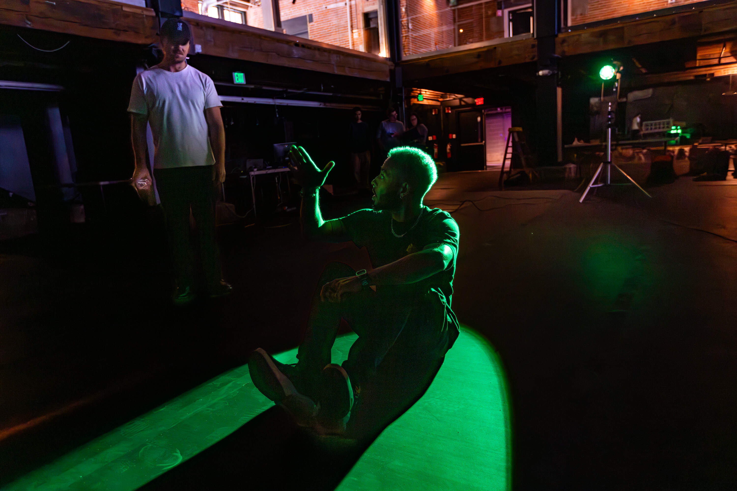 Caleb Hawkins discusses light projection concepts with MASARY Studios co-founder Sam Okerstrom-Lang during a test for an upcoming project. (Jesse Costa/WBUR)