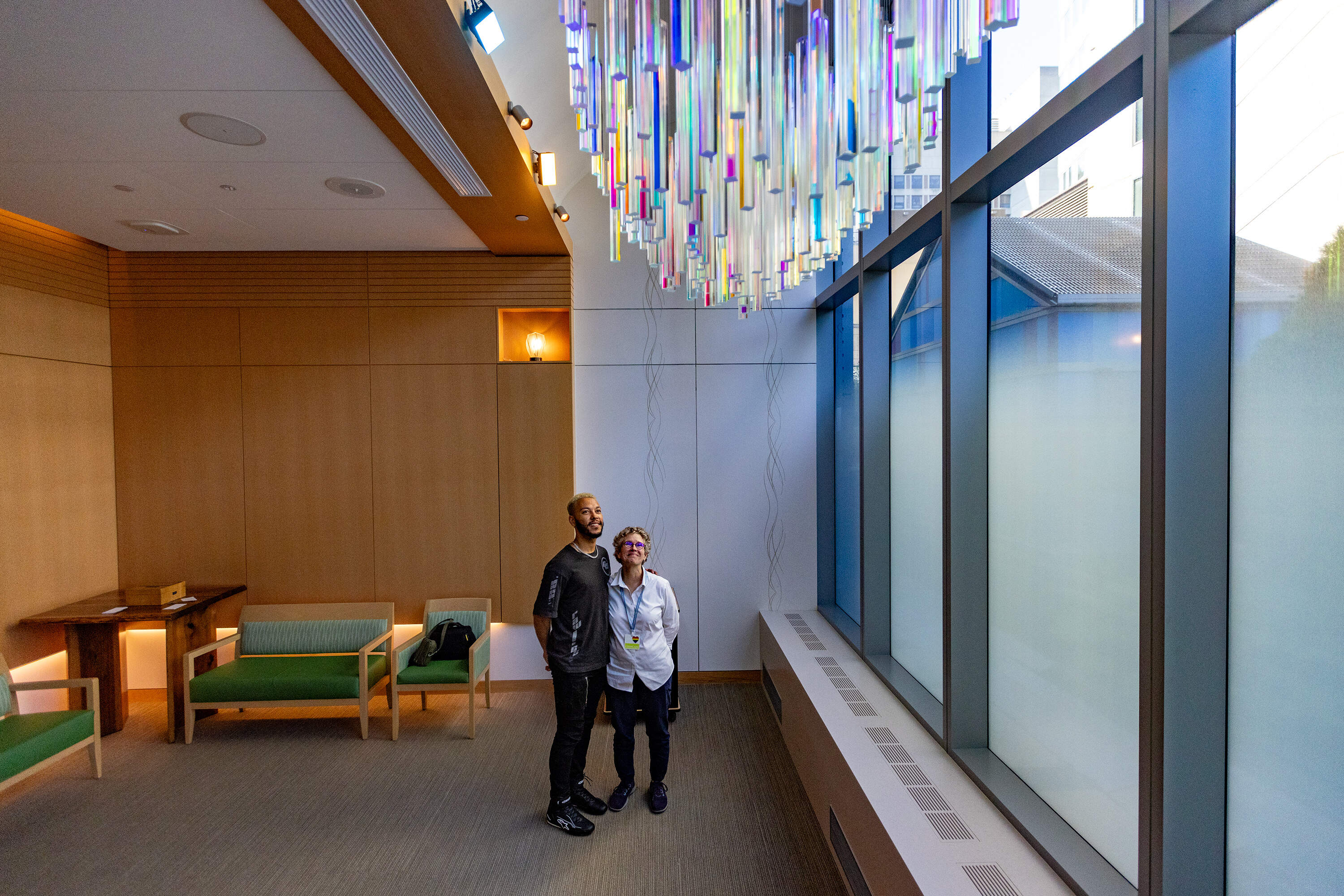 Caleb Hawkins and Rabbi Susan Harris look up at the "Refraction" installation in the chapel at Boston Children’s Hospital, which Hawkins designed. (Jesse Costa/WBUR)