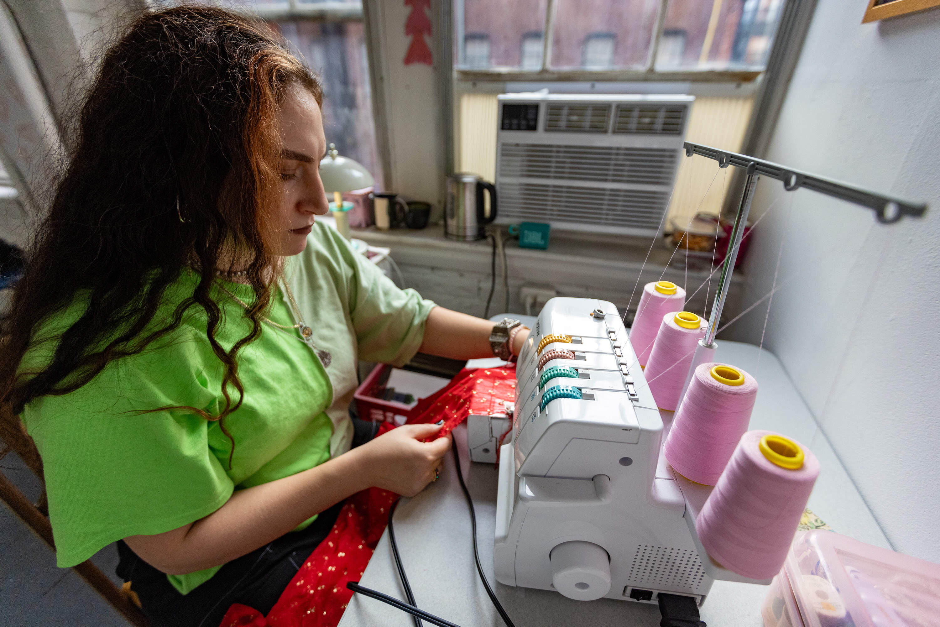 Artist Feda Eid hems a piece of fabric for a new gown she is making for her next photo piece at her studio at the Boston Center for the Arts. (Jesse Costa/WBUR)