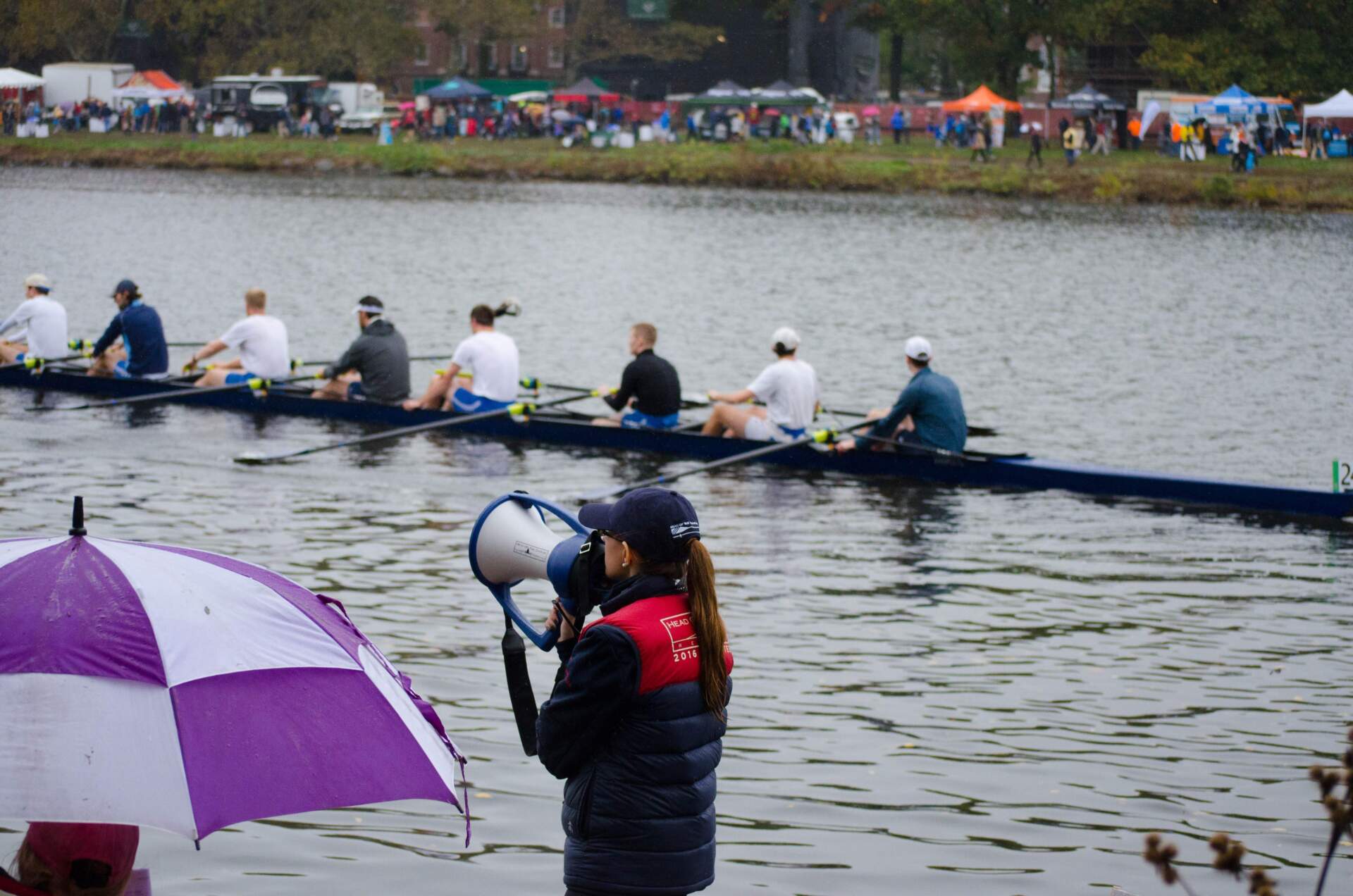 A HOCR staffer directs boats under the Weeks Footbridge by Harvard University. (Elizabeth Gillis/WBUR)