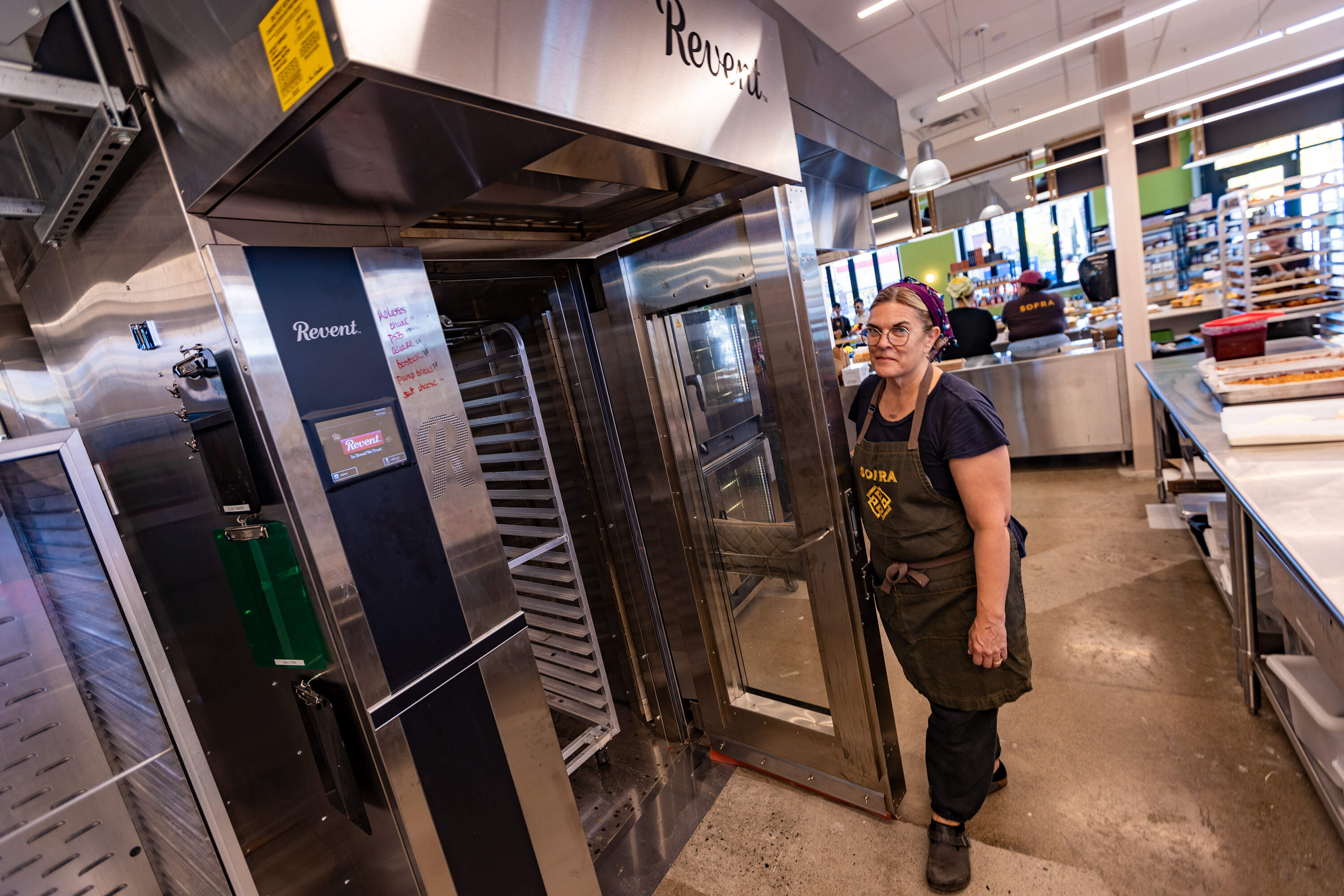 Ana Sortun opens the door to show off the size of the new large heating furnace. (Jesse Costa/WBUR)