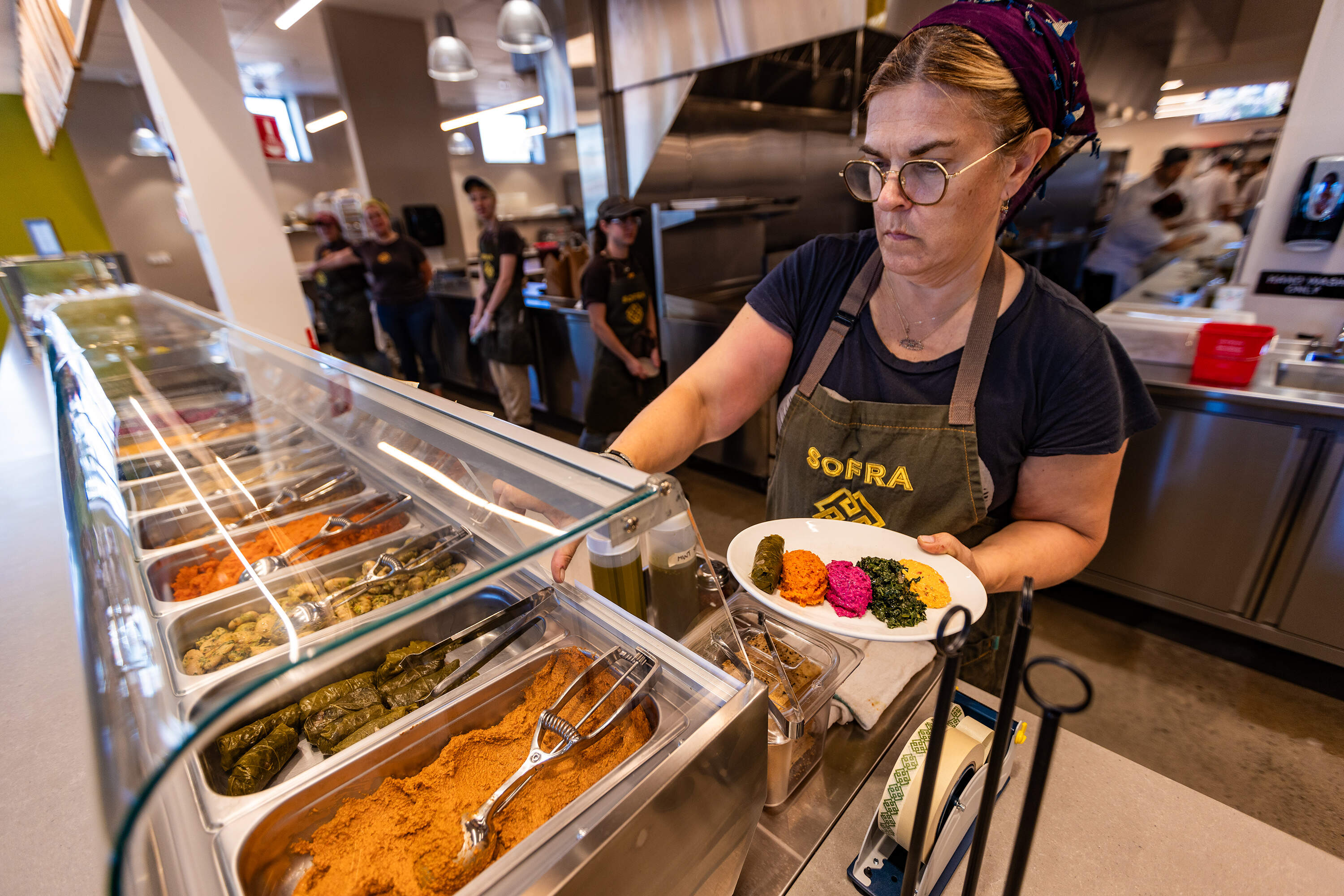 Executive chef and owner Ana Sortun prepares a salad at the cold cuts bar at the new Sofra location in Allston. (Jesse Costa/WBUR)