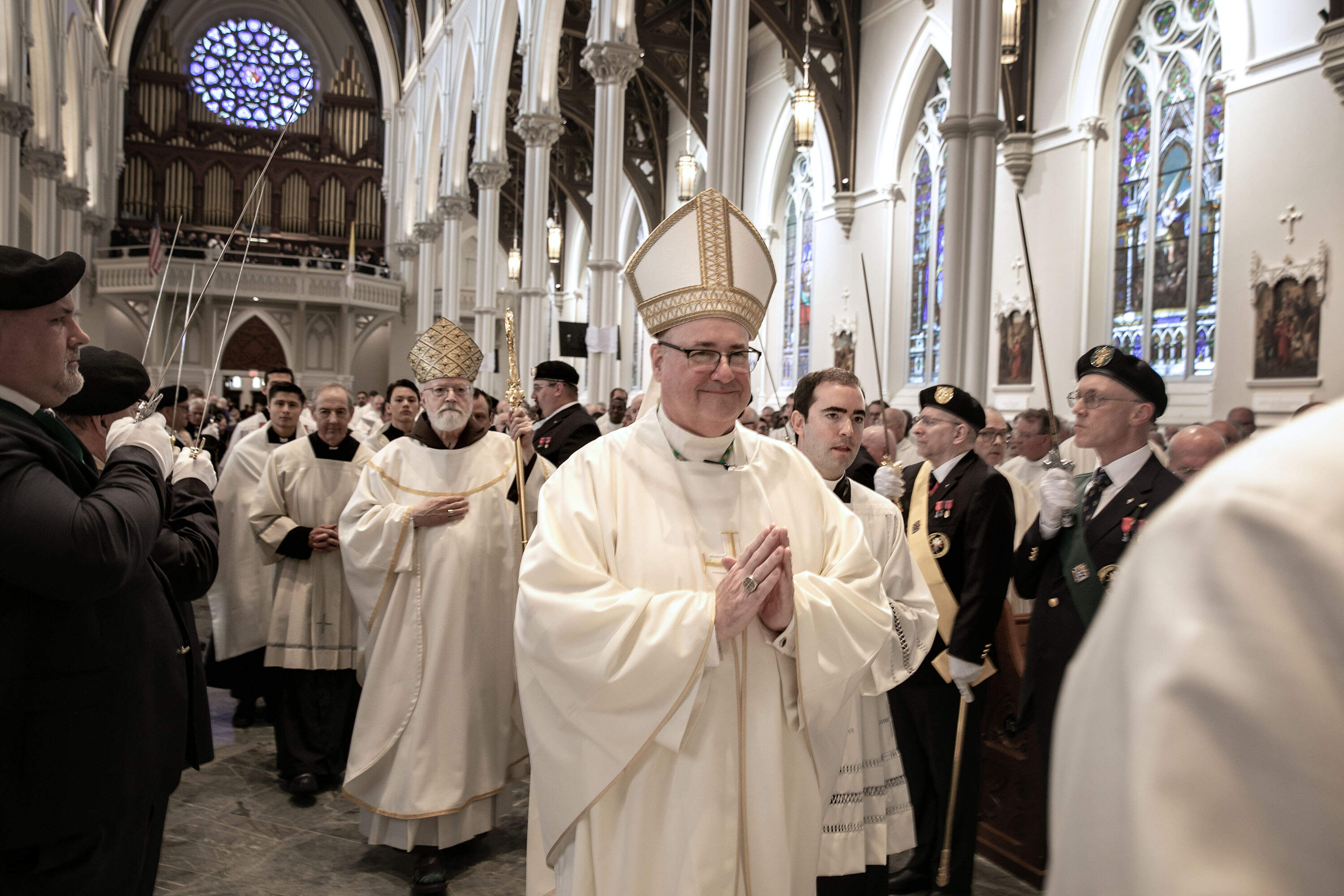 Richard Henning, followed by Cardinal Seán O'Malley, walks into the Cathedral of the Holy Cross. (Robin Lubbock/WBUR)