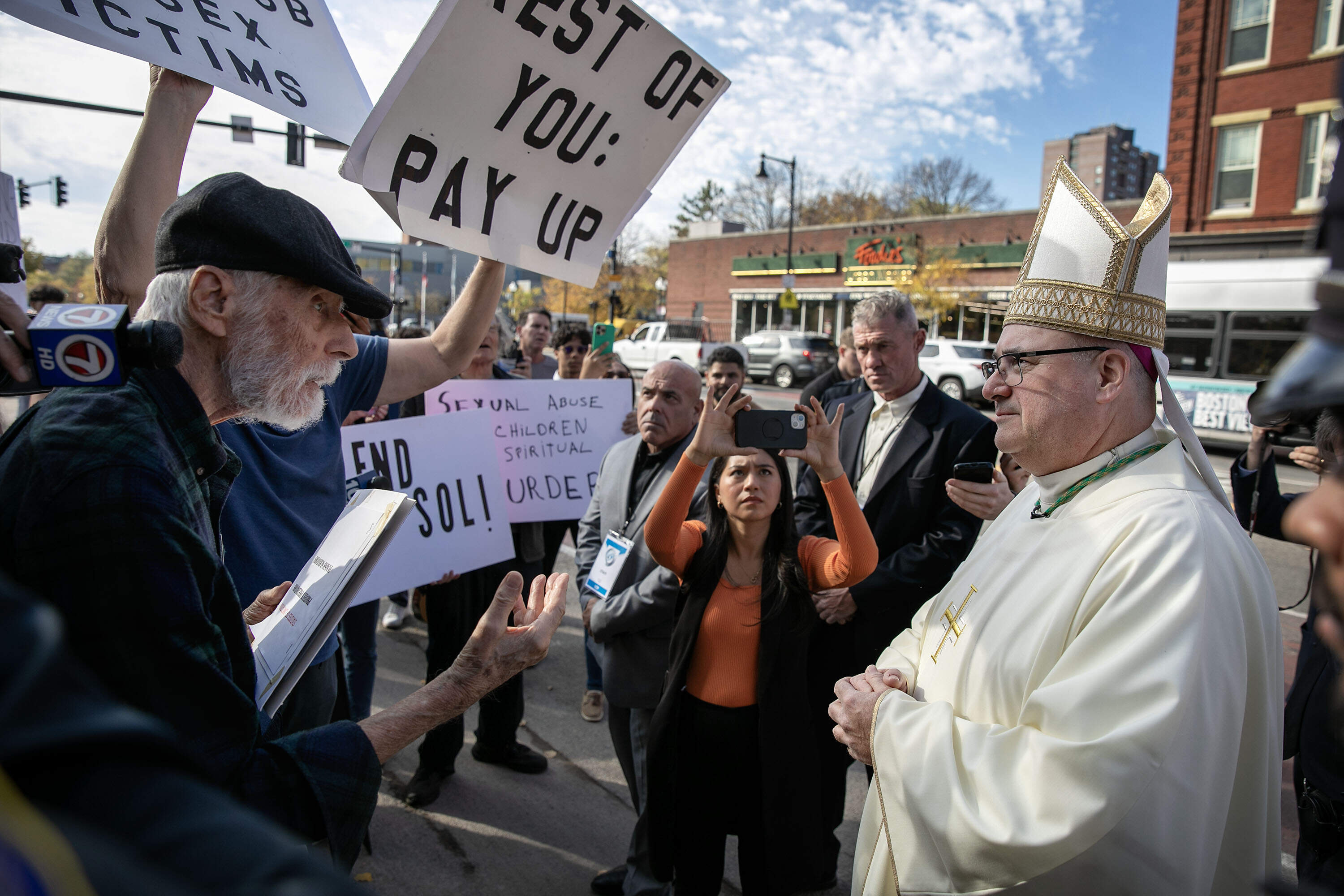 Before entering the Cathedral of the Holy Cross to be installed as archbishop of the Archdiocese of Boston, Richard Henning paused to speak with protestors for victims of clergy sexual abuse. (Robin Lubbock/WBUR)