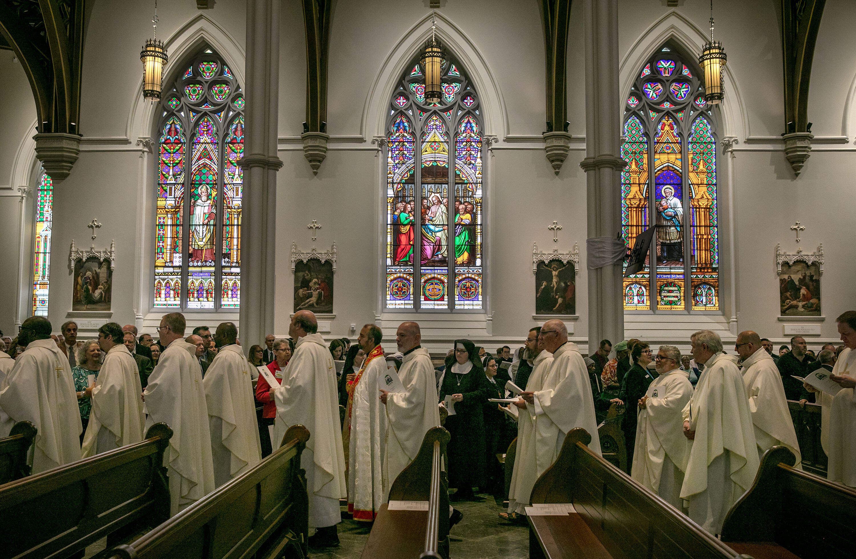 Priests walk through the Cathedral of the Holy Cross. (Robin Lubbock/WBUR)