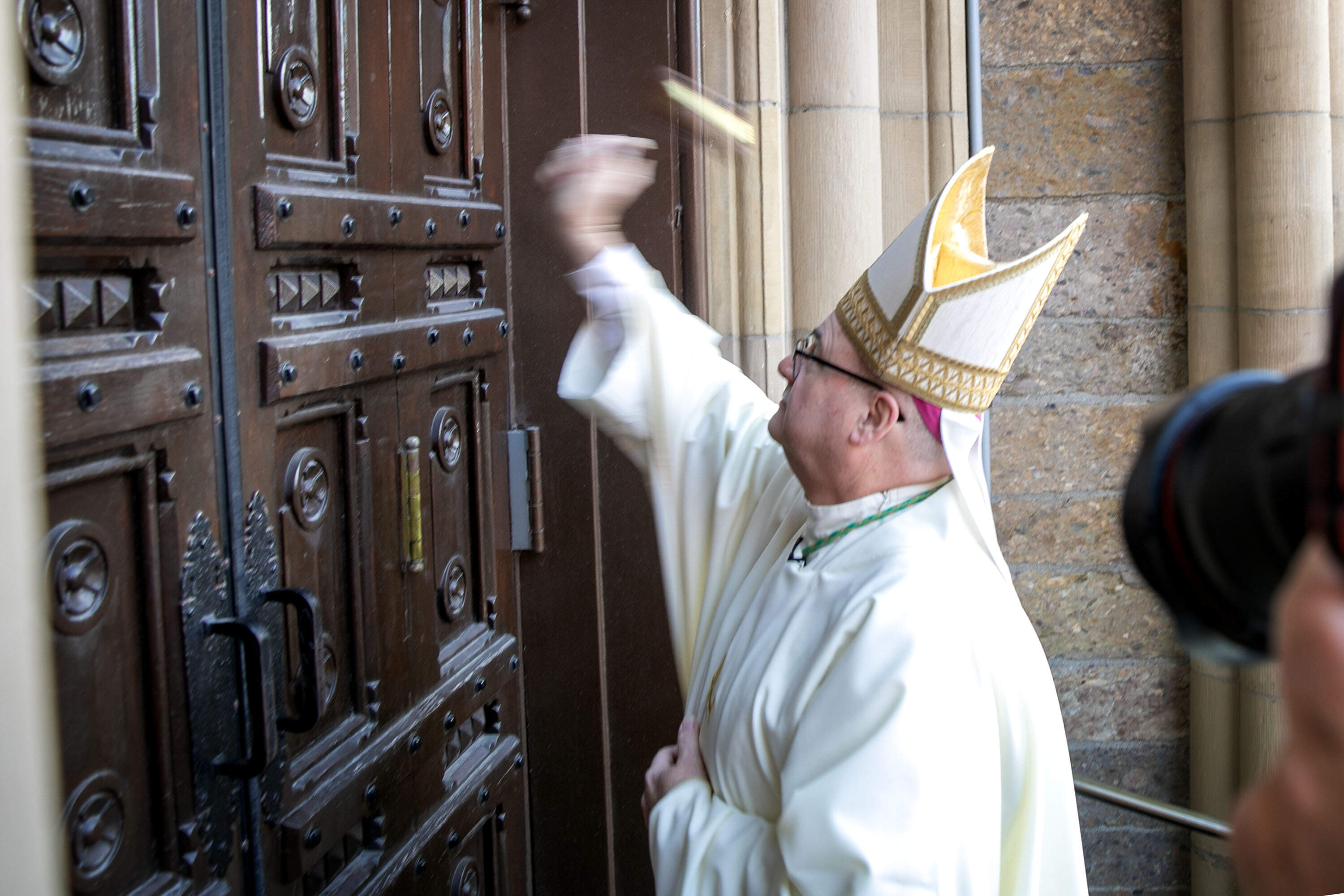 Bishop Richard Henning knocks on the door of the Cathedral of the Holy Cross before entering for the ceremony to install him as Boston's archbishop. (Robin Lubbock/WBUR)