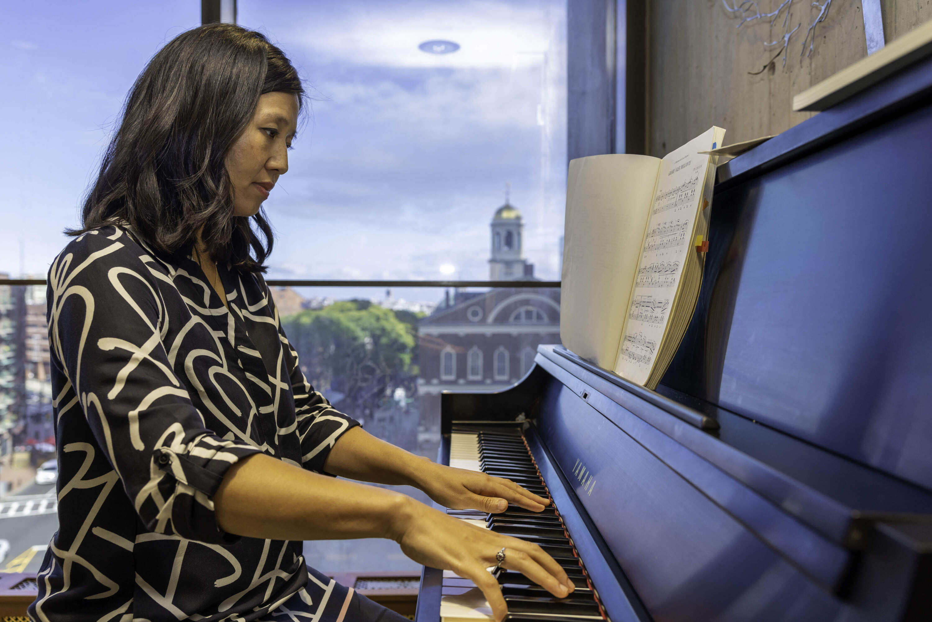 Boston Mayor Michelle Wu plays the piano in her office on September 24, 2024 (Courtesy Mike Mejia/Mayor Wu's office)