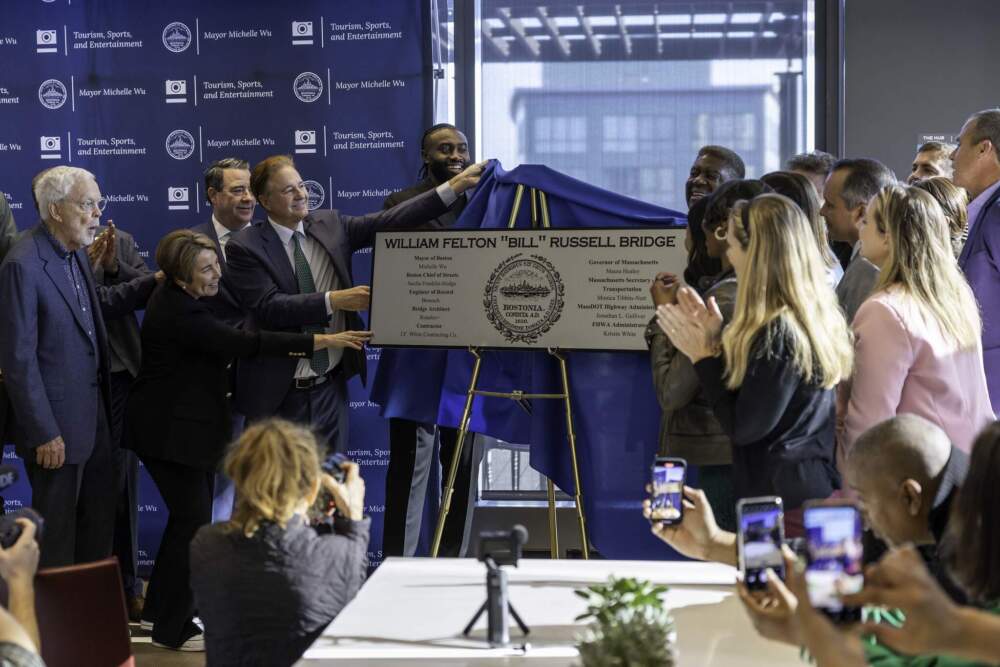 Celtics star Jaylen Brown (center), Gov. Healey (second from left) and other ceremony attendees unveil the sign for the Bill Russell bridge. (Courtesy of Mike Mejia from the City of Boston)