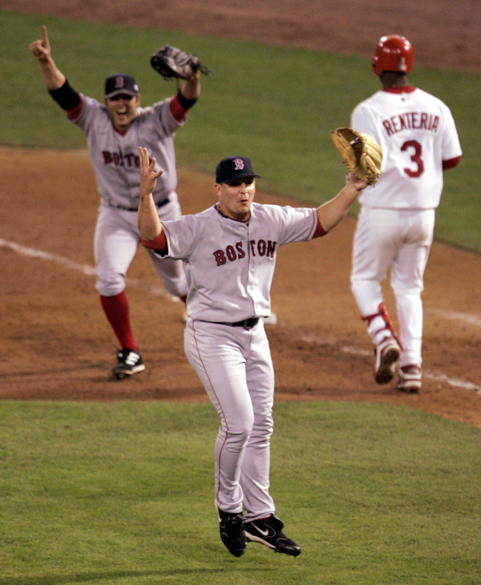 Boston Red Sox pitcher Keith Foulke, center, and first baseman Doug Mientkiewicz, left, celebrate after St. Louis Cardinals' Edgar Renteria grounded out to end the ninth inning and give Boston a 3-0 win and a sweep of the World Series, Wednesday Oct. 27, 2004, in St. Louis. (Mark Humphrey/AP)