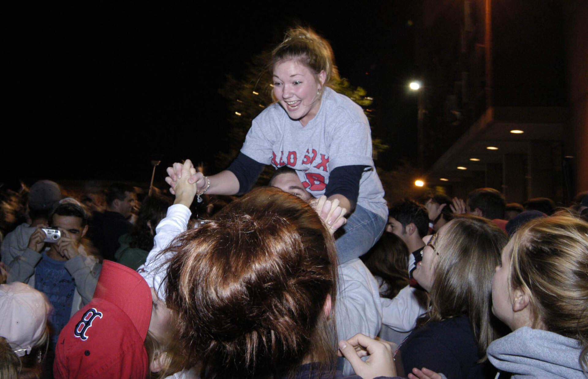 Ashley Davis, a student at the University of Massachusetts in Amherst, Mass., top, celebrates with her friends on the school's campus after the Boston Red Sox's 3-0 victory over the St. Louis Cardinals in Game 4 of the World Series. The Red Sox swept the Cardinals for their first crown since 1918. (Dennis Vandal/AP)