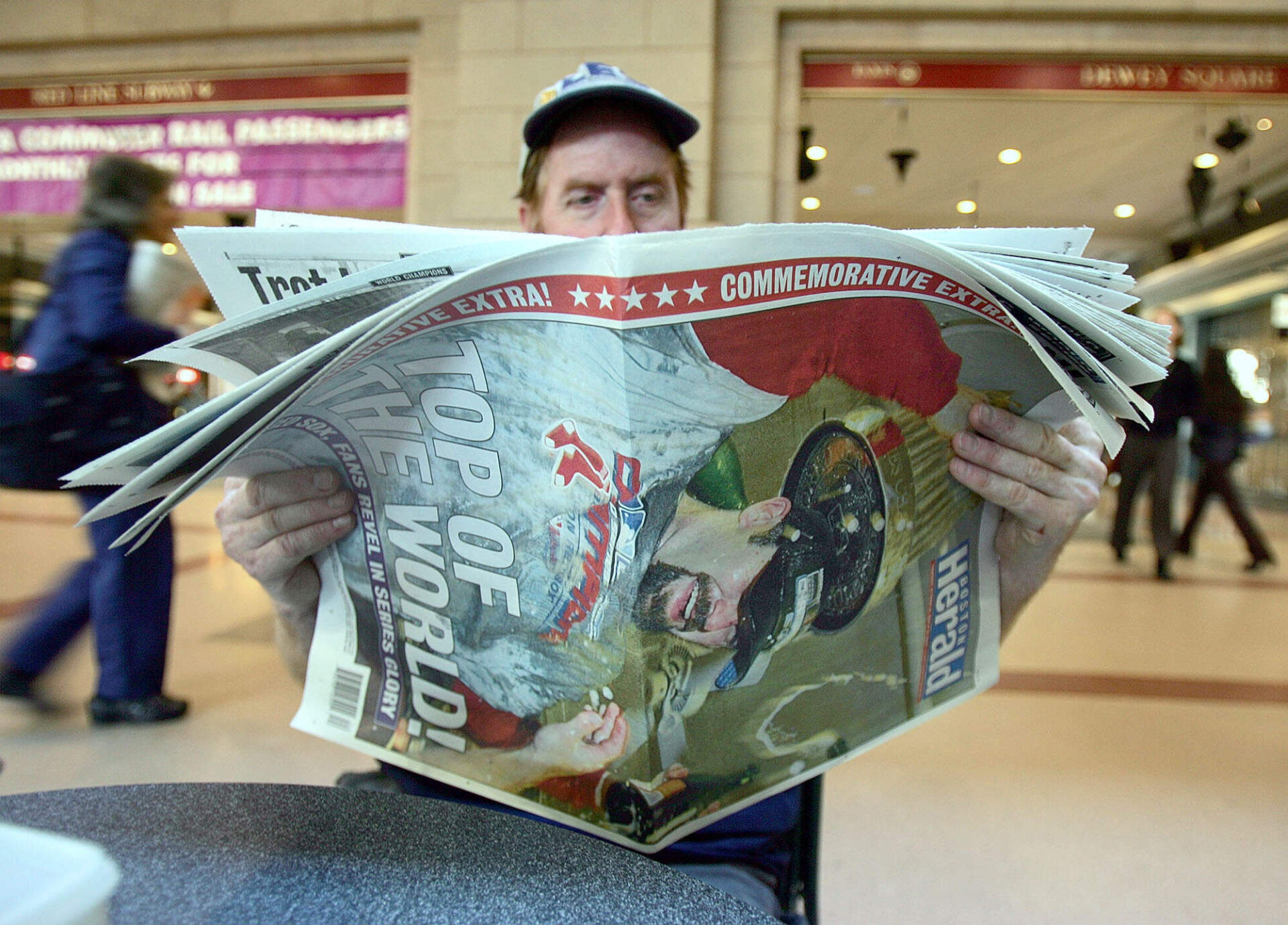 Dan Curran, of Boston, reads a newspaper reporting the Red Sox victory in the World Series on the front page, at the South Station in Boston, Thursday, Oct. 28, 2004. (Chitose Suzuki/AP)