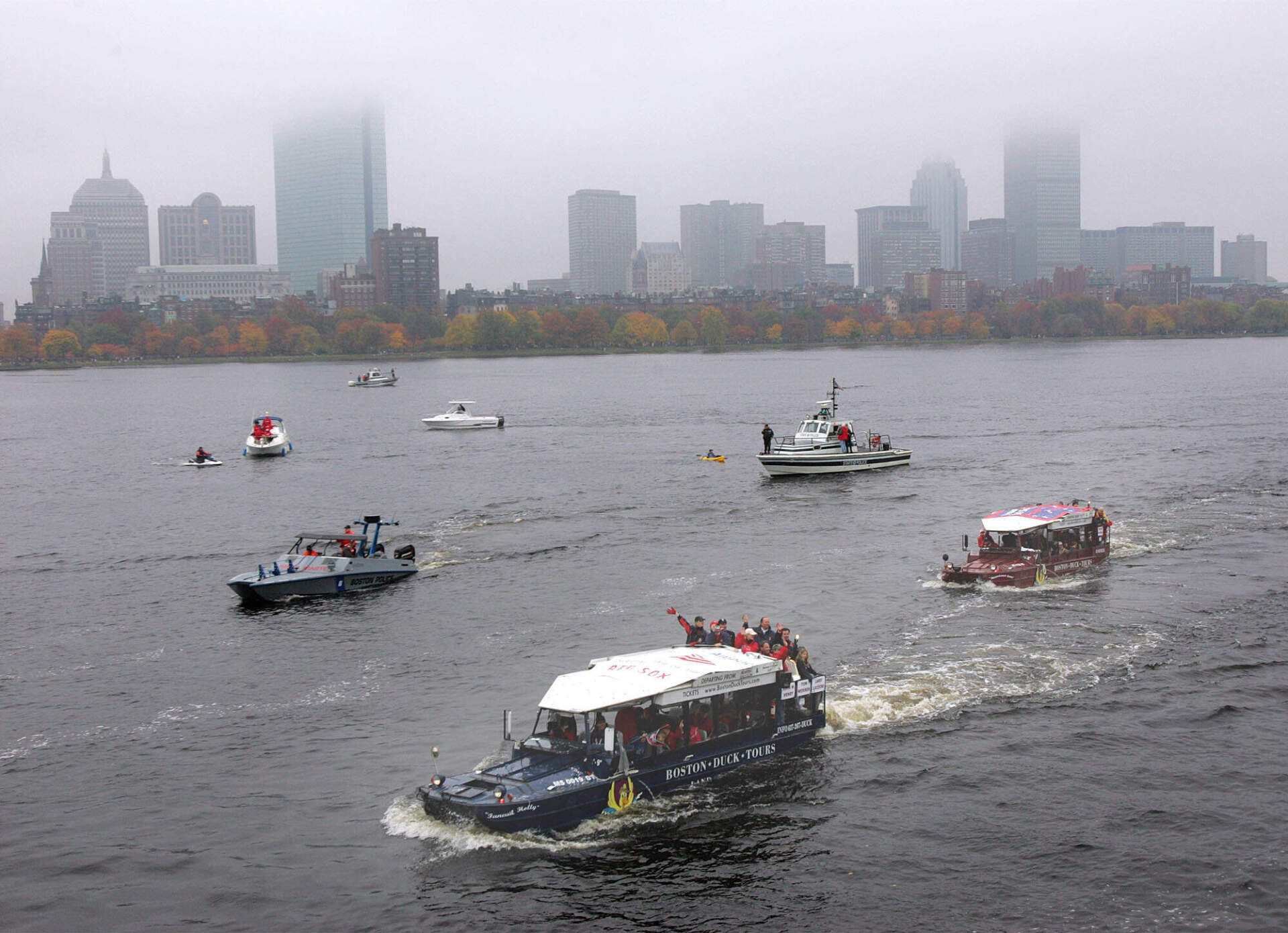 Boston Red Sox players and officials wave to spectators from the Duck boats while motoring along the Charles River on the Cambridge, Mass. side during the Red Sox's World Series Championship parade, Saturday, Oct. 30, 2004. (Chitose Suzuki/AP)