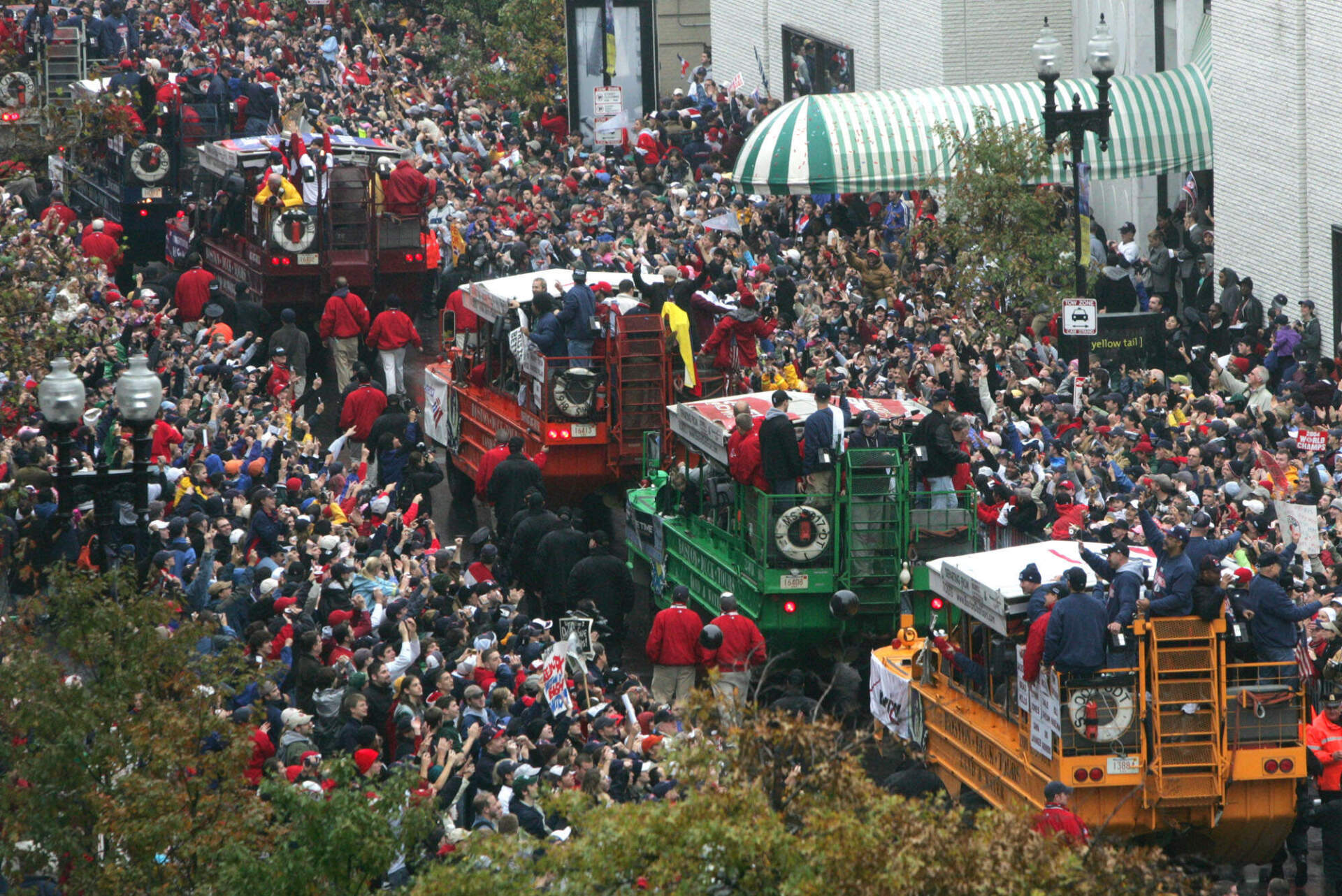 Fans surround vehicles carrying members of the Boston Red Sox during the Red Sox World Series Championship parade through the streets of Boston, Saturday Oct. 30, 2004. (Charles Krupa/AP)