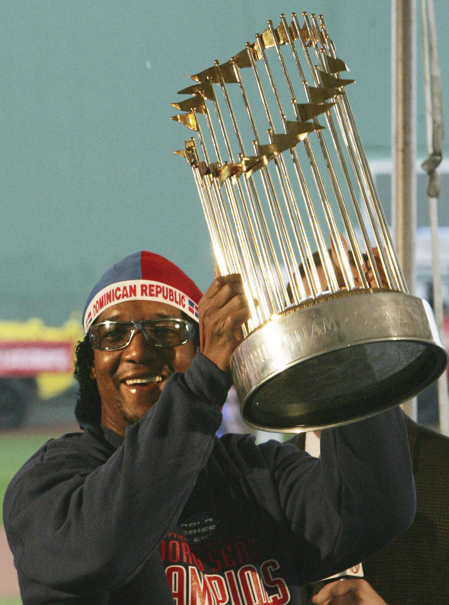 Boston Red Sox pitcher Pedro Martinez hoists the World Series trophy at the start of the rolling rally at Fenway Park in Boston in 2004. (Charles Krupa/AP)