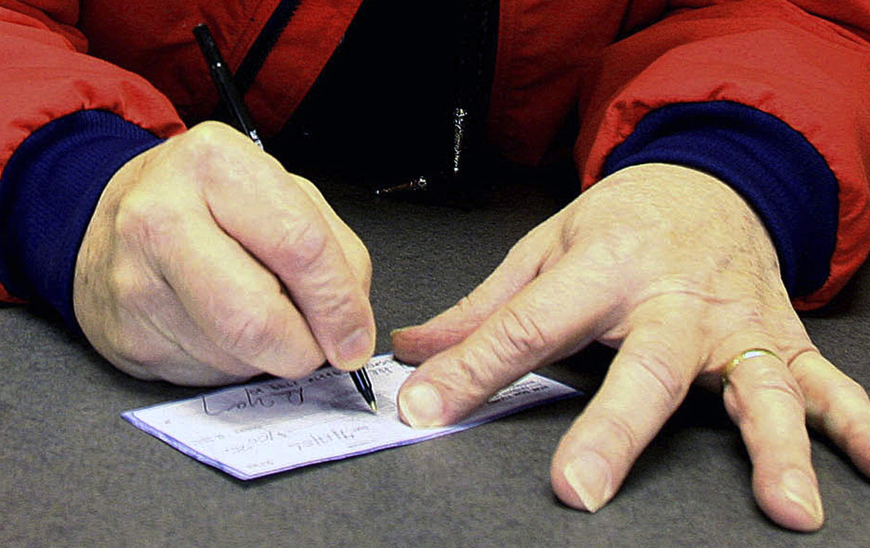 A man signs a check in Anchorage, Alaska. (Al Grillo/AP)