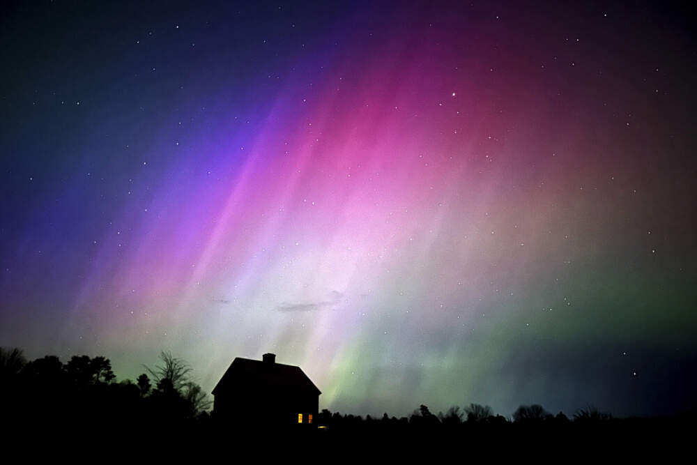 The northern lights flare in the sky last May over a farmhouse in Brunswick, Maine. (AP Photo/Robert F. Bukaty)