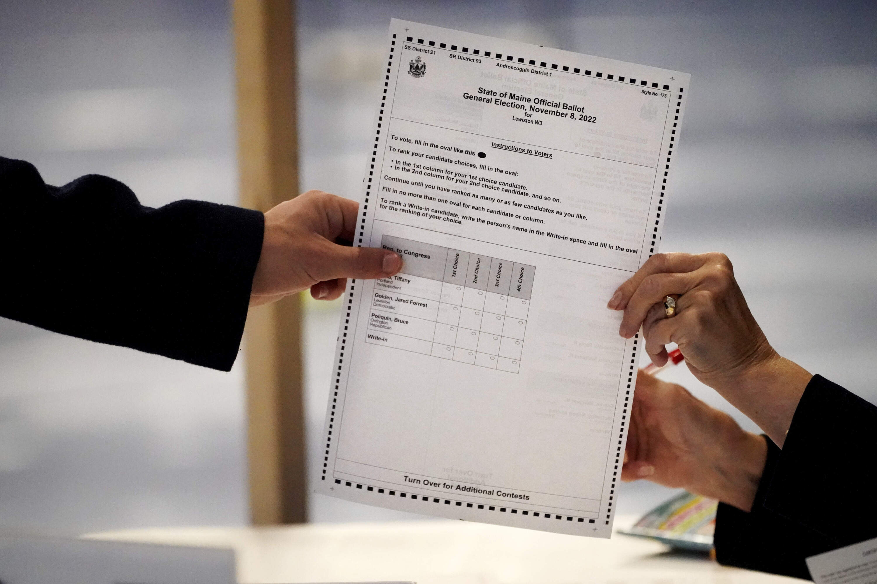 FILE - A clerk in Lewiston, Maine hands a ballot to a voter in 2022. Maine uses a ranked-choice voting system for some of its election races. (Robert F. Bukaty/AP)