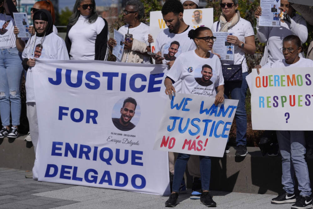 People display signs with with a likeness of Massachusetts State Police recruit Enrique Delgado-Garcia, who died following a State Police Academy training exercise, at a protest outside the State Police Academy graduation ceremony, Wednesday, Oct. 9, 2024, at the DCU Center, in Worcester, Mass. (Steven Senne/AP)