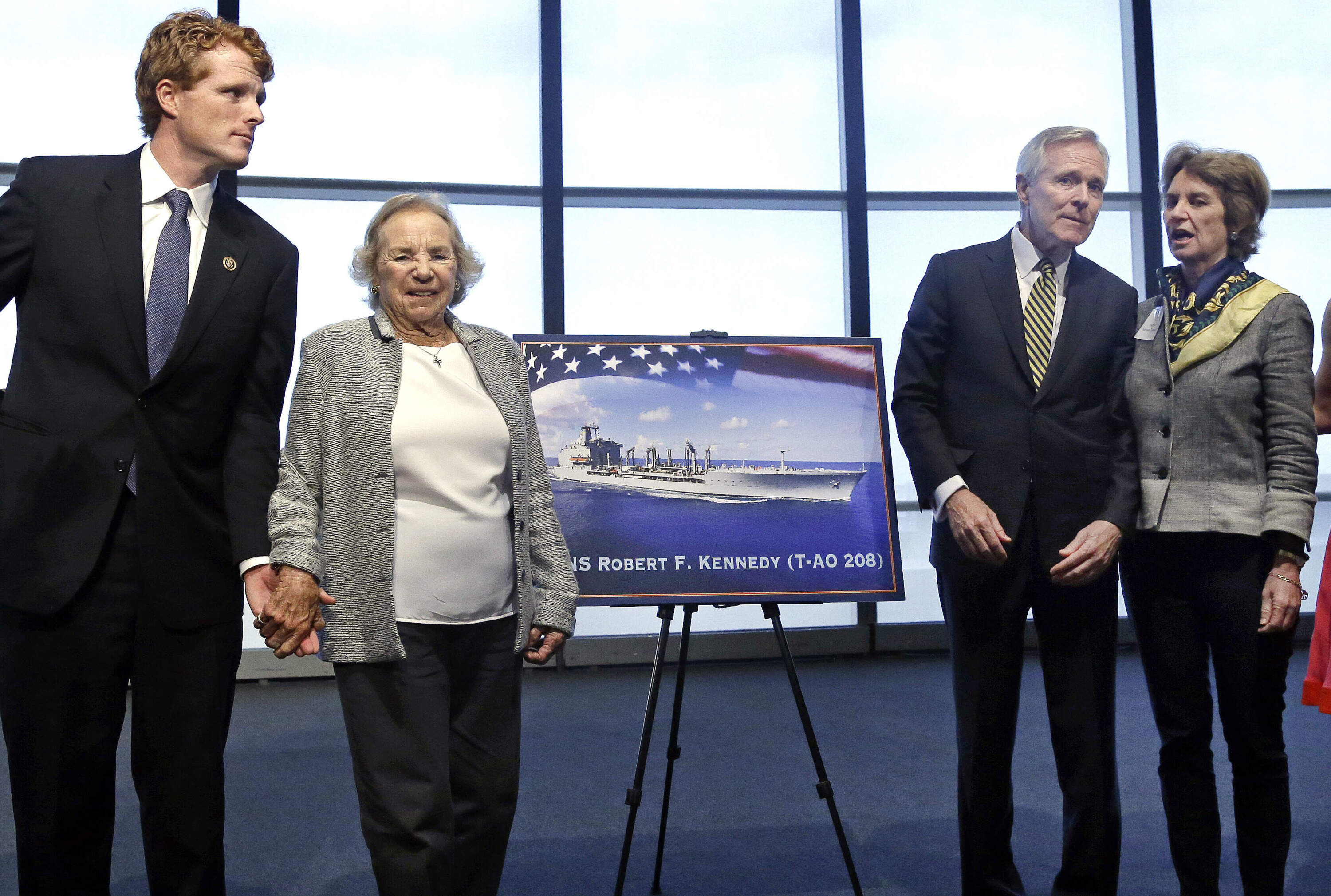 Ethel Kennedy holds hands with grandson Joseph P. Kennedy III, left, while Navy Secretary Ray Mabus chats with her daughter Kathleen Kennedy Townsend, as they pose near a rendering of the Robert F. Kennedy Navy Ship in 2016. (Elise Amendola/AP)