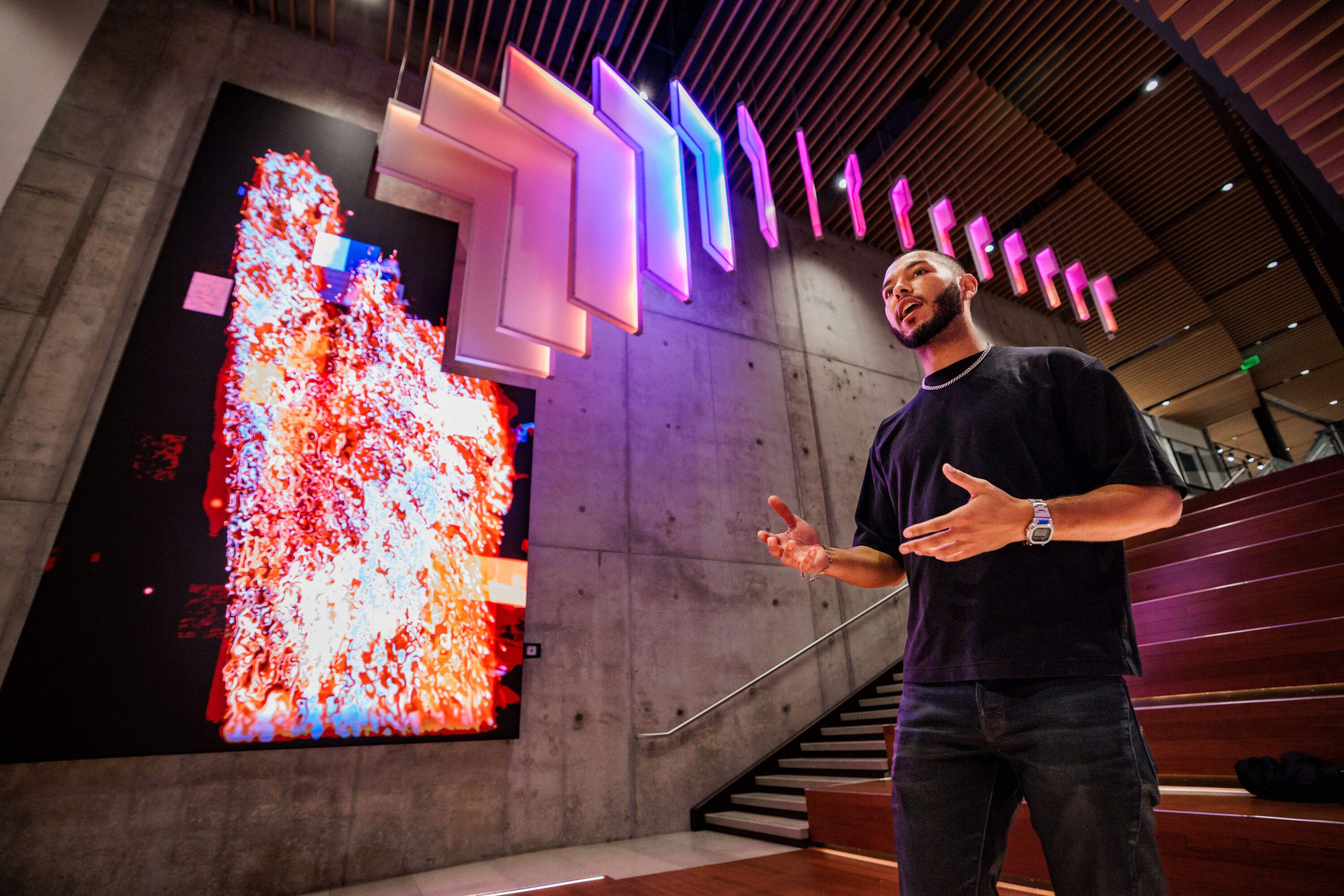 Caleb Hawkins speaks to a group of attendees as part of a tour of the new artwork, "Memory / Diffusion" at the Boston Arts Academy. (Courtesy Aram Boghosian)
